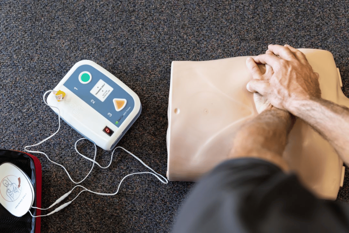 Hands-on DRSABCD training at ETA Training Perth, practising CPR and emergency response on a mannequin with an AED trainer device