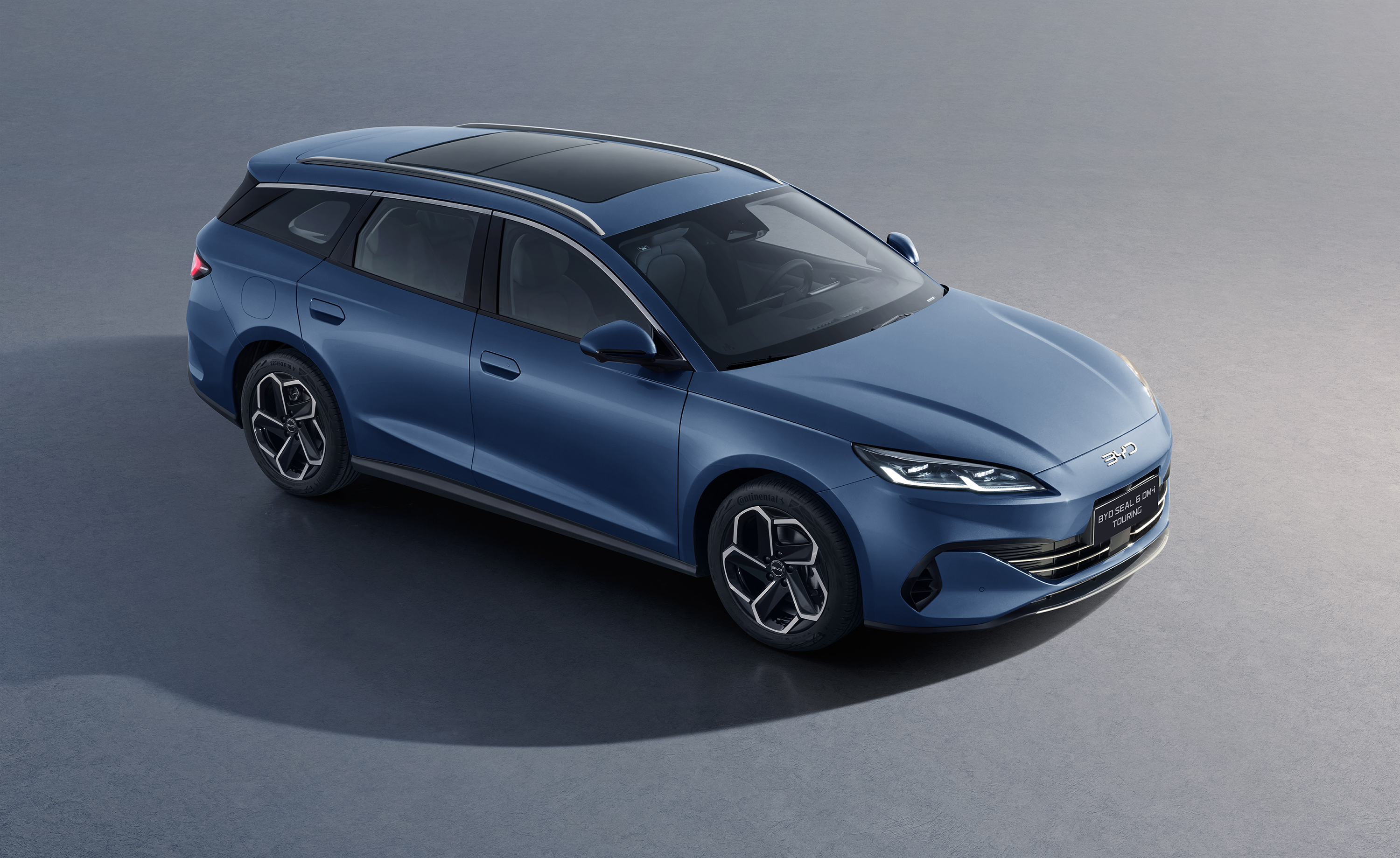 BYD SEAL U DM-i, Komplettansicht von 30° von vorne, Mann fotografiert mit Hund, Sonnenuntergang und Horizont im Hintergrund