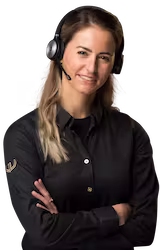 Vrouw met lichtbruine haren die een headset draagt en haar armen gekruist heeft, glimlachend in een zwarte blouse.