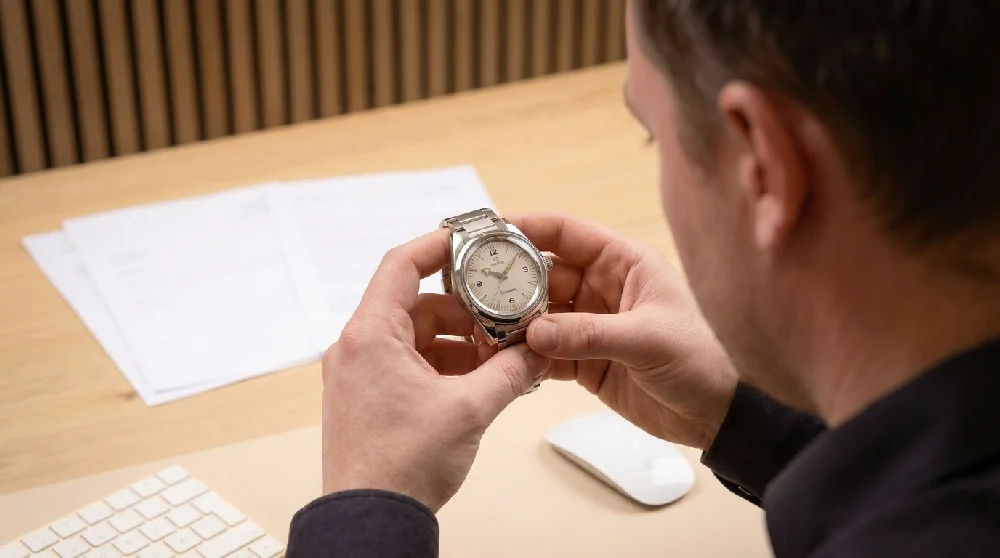 Horloge-expert inspecteert Omega Railmaster met loep.