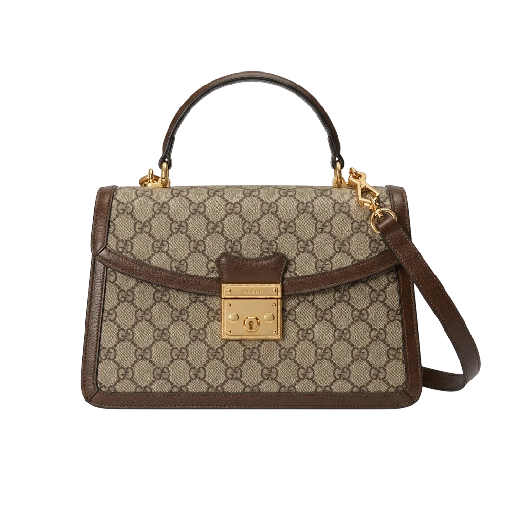 Gucci Ophidia GG Medium schoudertas in kenmerkende bruine kleuren met GG-logo en goudkleurig beslag op een neutrale achtergrond, met de riem aan de zijkant weggestopt.