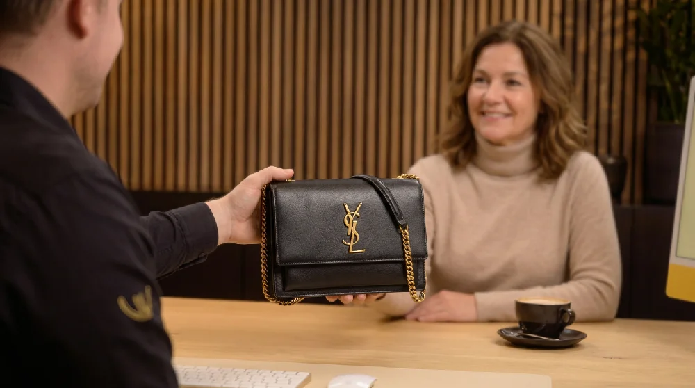 Vrouw vult online formulier in op tablet voor verpanding Saint Laurent tas