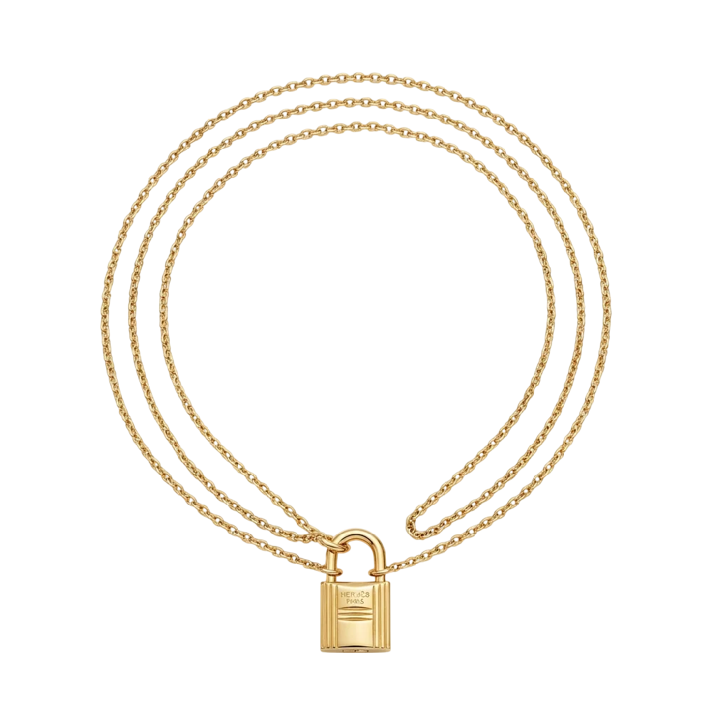Close-up van een Hermès Kelly Clochette sieraad in goud met leren accenten.