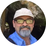 A man wearing glasses and a hat.
