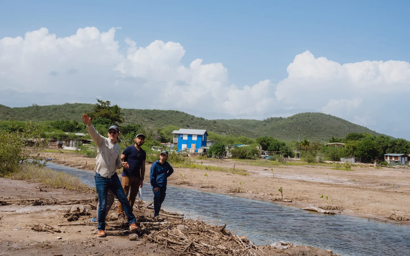 A group of people standing next to a river.