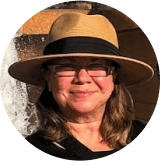 A woman wearing a hat and glasses.