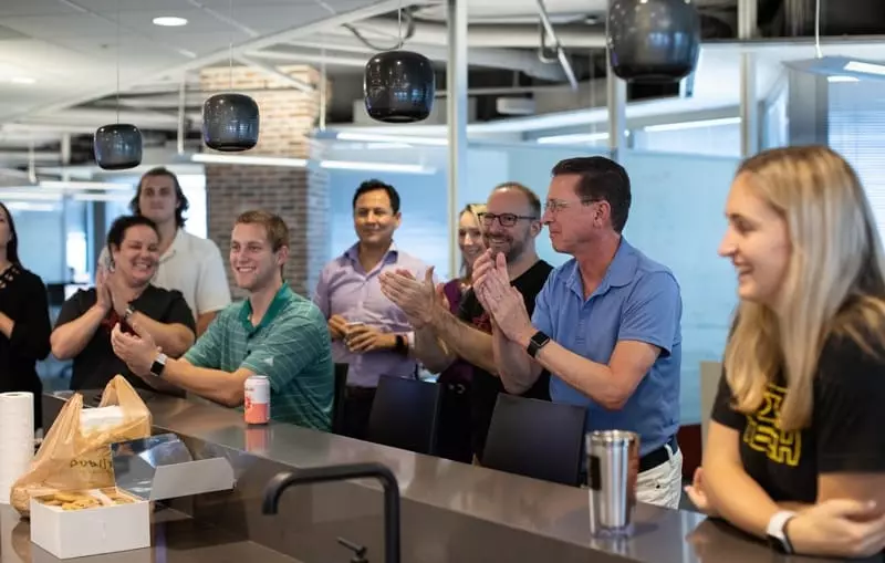 SOLTECH team members celebrate together in an office setting