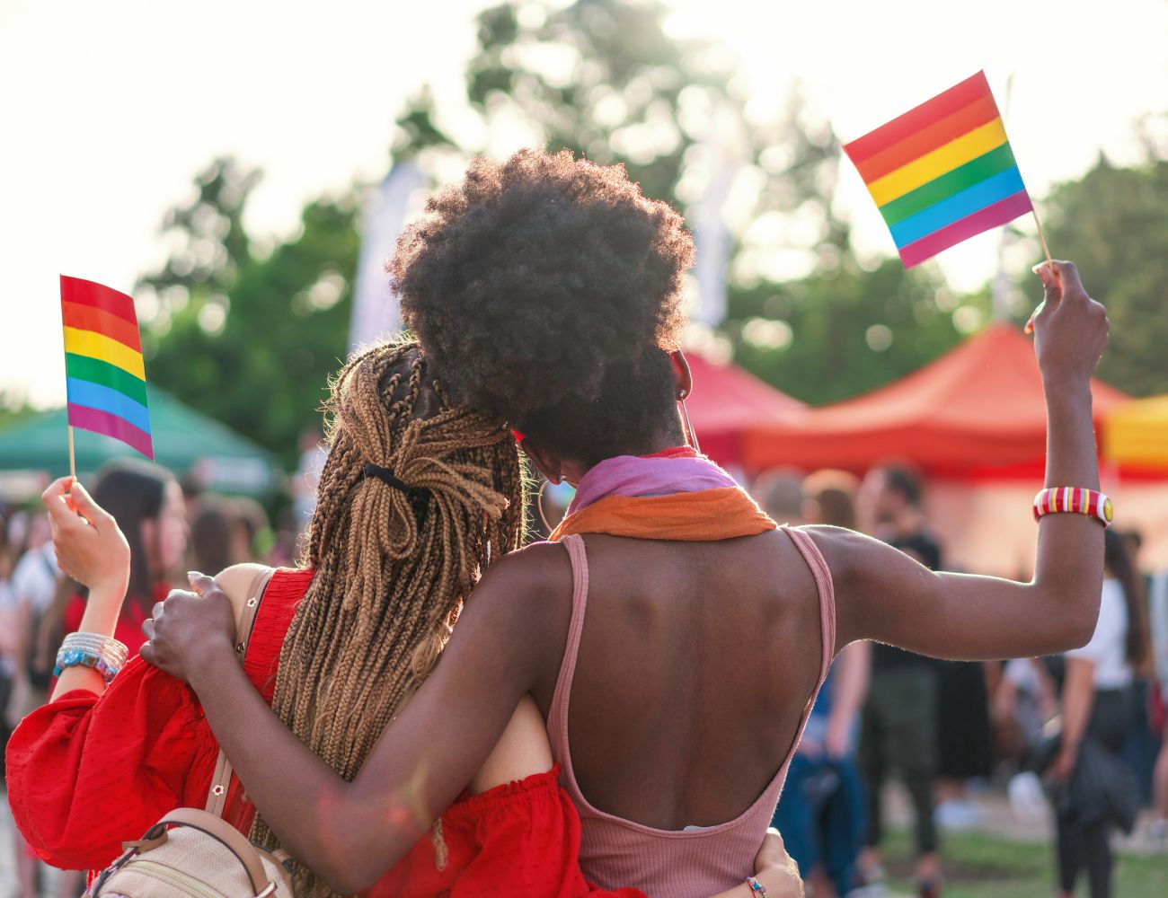 two people pose together with their pride flags during a festival