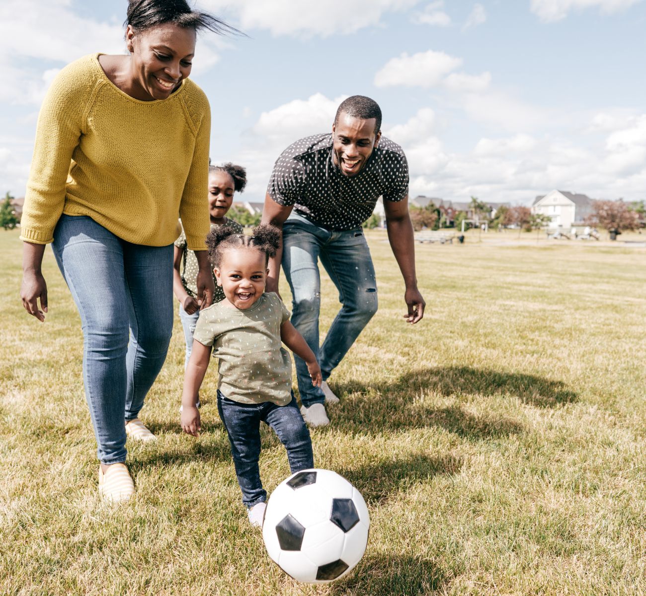 a family plays soccer together in a park