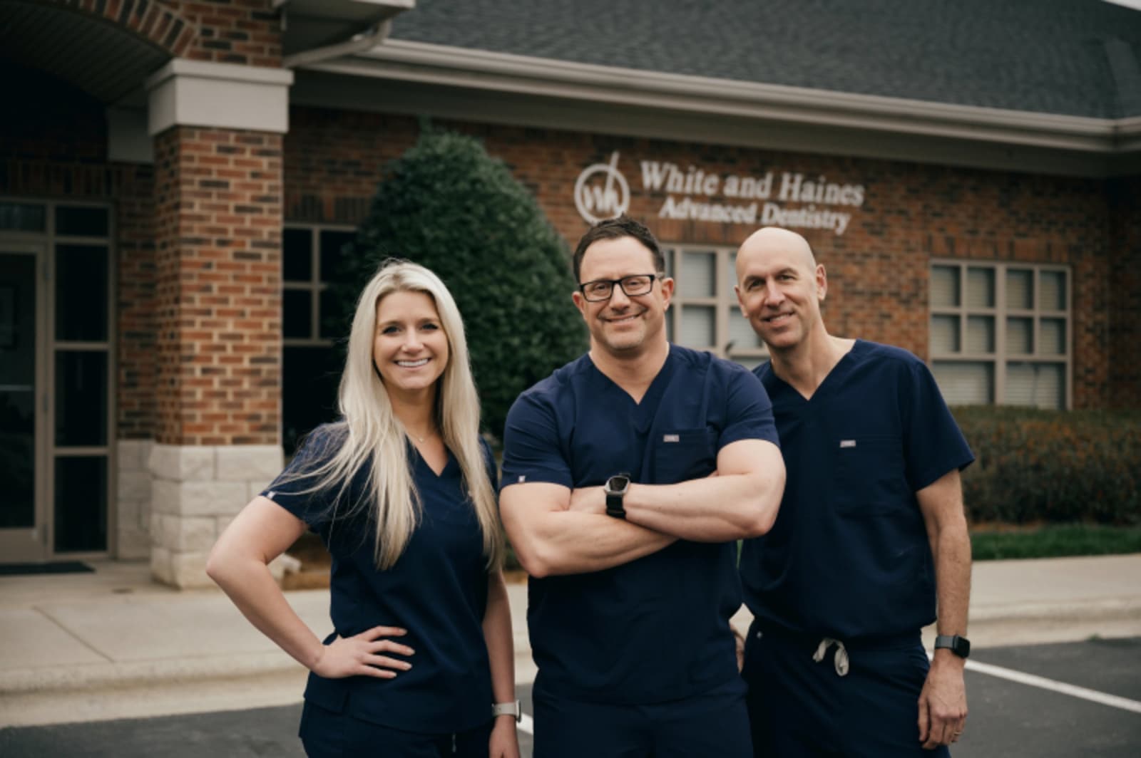 Three White and Haines Advanced Dentistry team members posing together outside