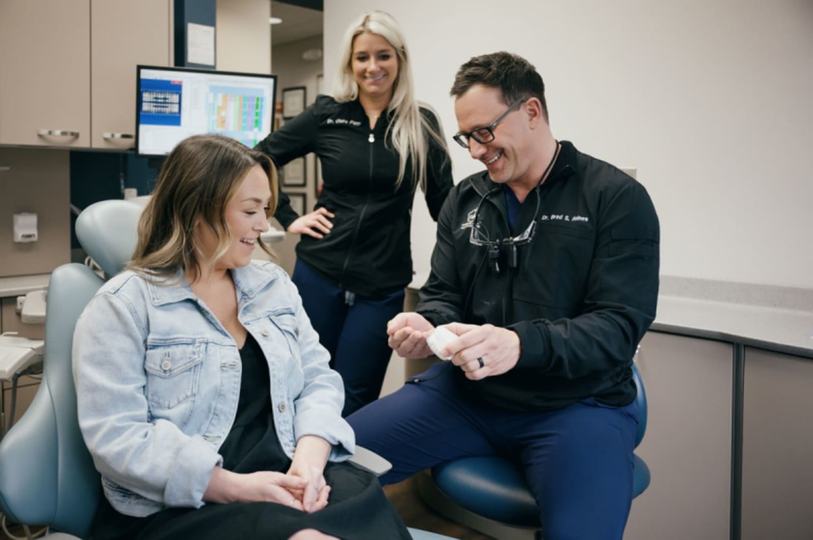 White and Haines dentist team member explaining implant-supported dentures to a patient in the office.