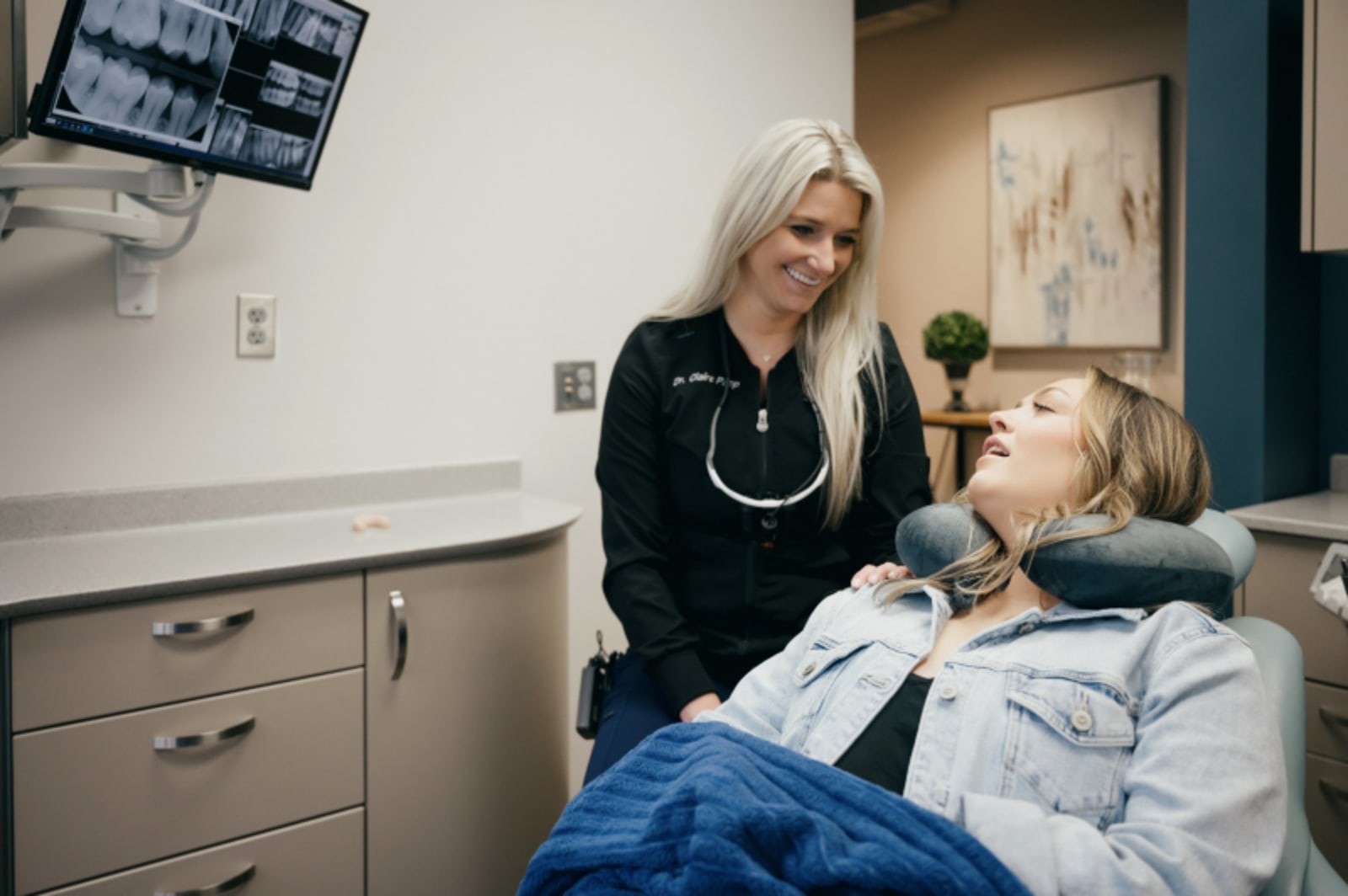Dentist explaining teeth whitening procedure to patient in treatment room