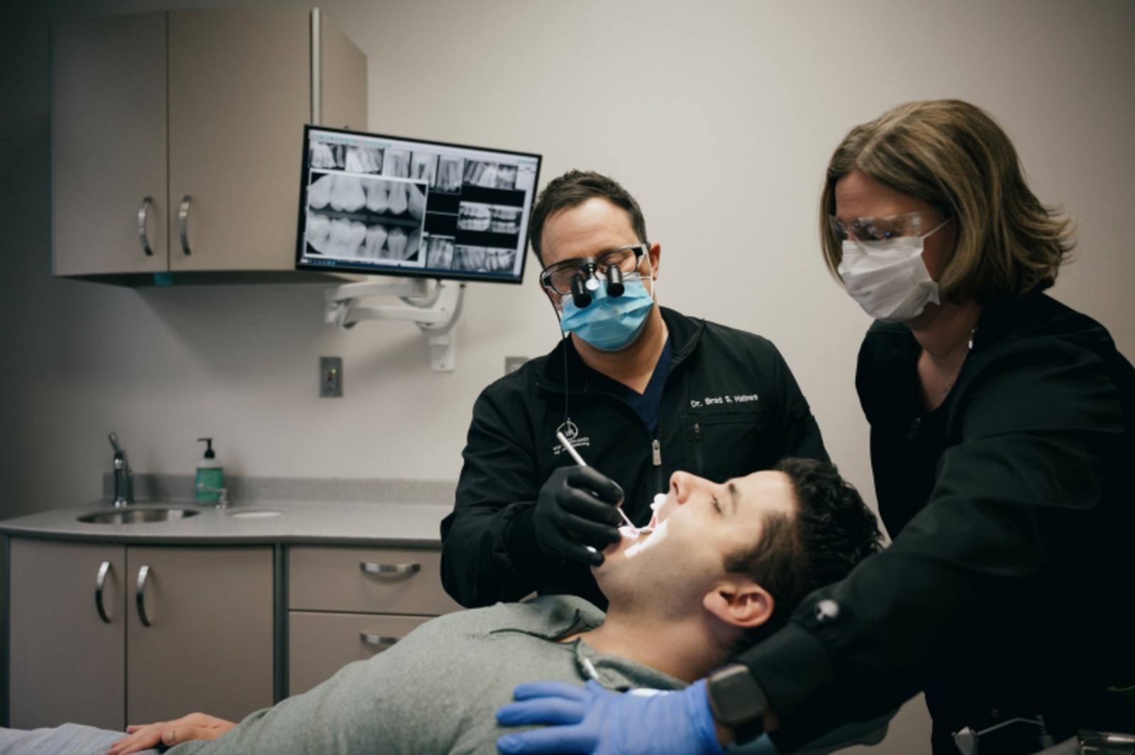 Dental professional examining patient's teeth during whitening treatment