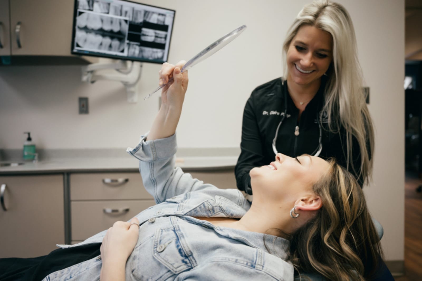 Dentist applying composite bonding material to a patient's front tooth during treatment