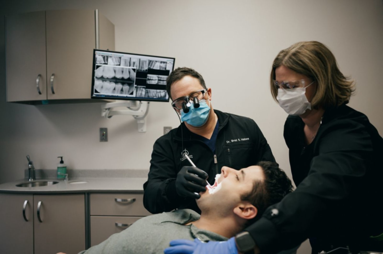 Dentist examining patient's teeth during first appointment at White and Haines Advanced Dentistry.
