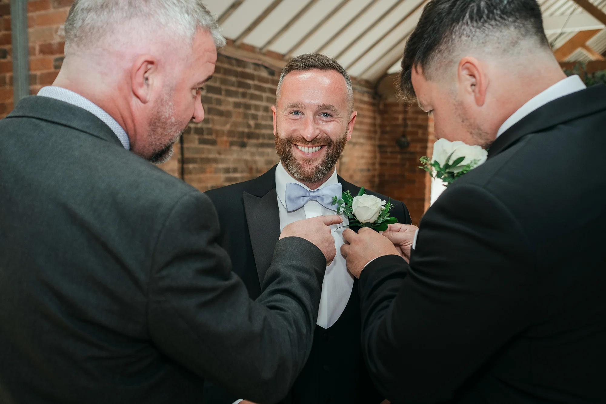 Groom having his buttonhole pinned before the ceremony at Blackbrook Barns, Lichfield, Staffordshire