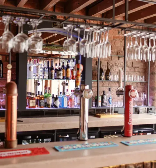 The Gallery Bar with hanging glassware and spirits at Blackbrook Barns, Lichfield, Staffordshire