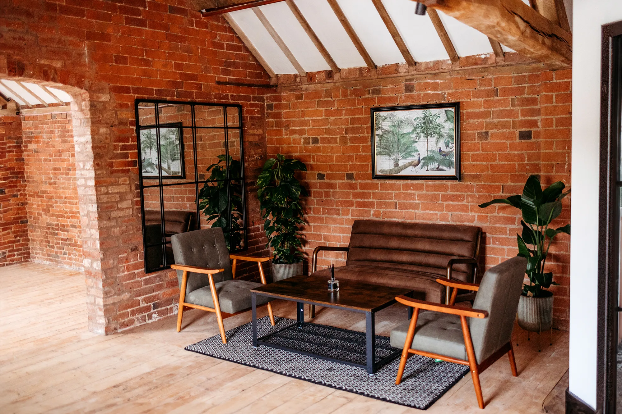 Brick-walled prep room lounge with sofa and armchairs at Blackbrook Barns, Lichfield, Staffordshire