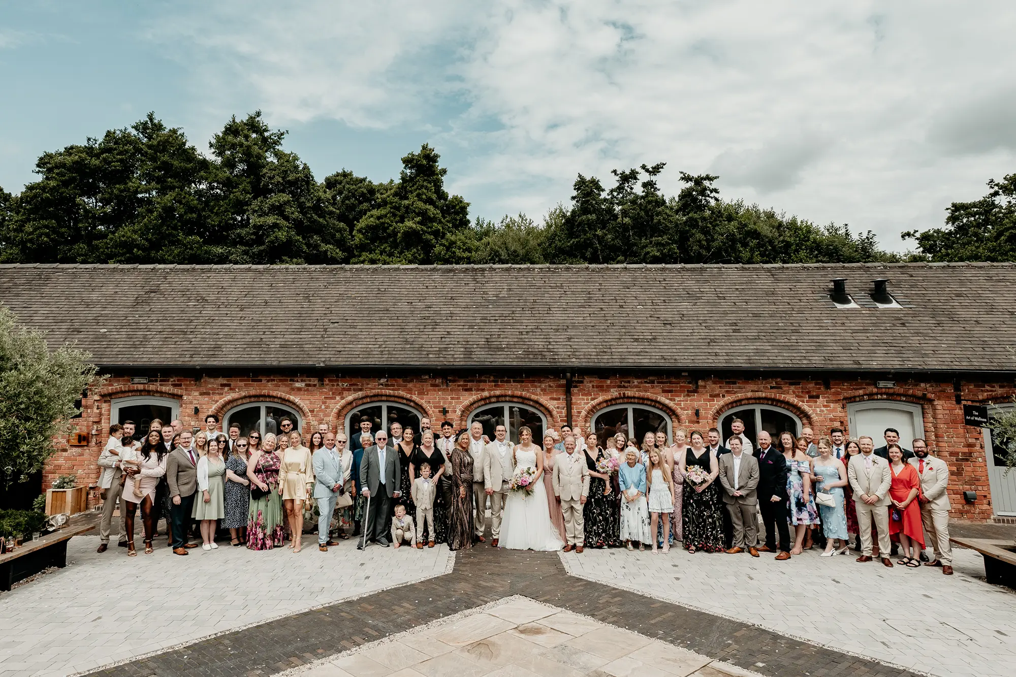 Full wedding party group photograph outside the barn at Blackbrook Barns, Lichfield, Staffordshire