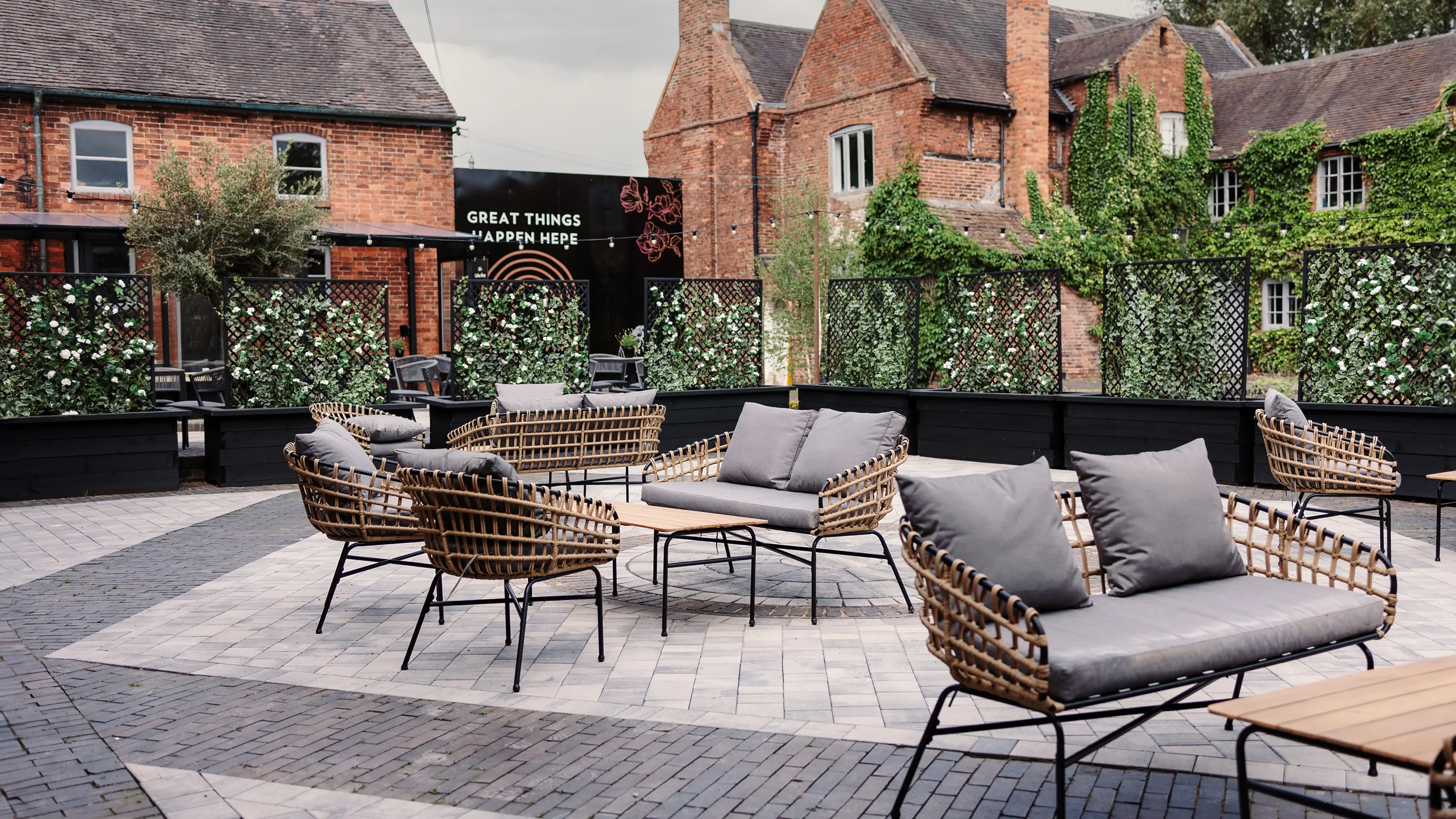 The Upper Courtyard with outdoor rattan seating at Blackbrook Barns, Lichfield, Staffordshire