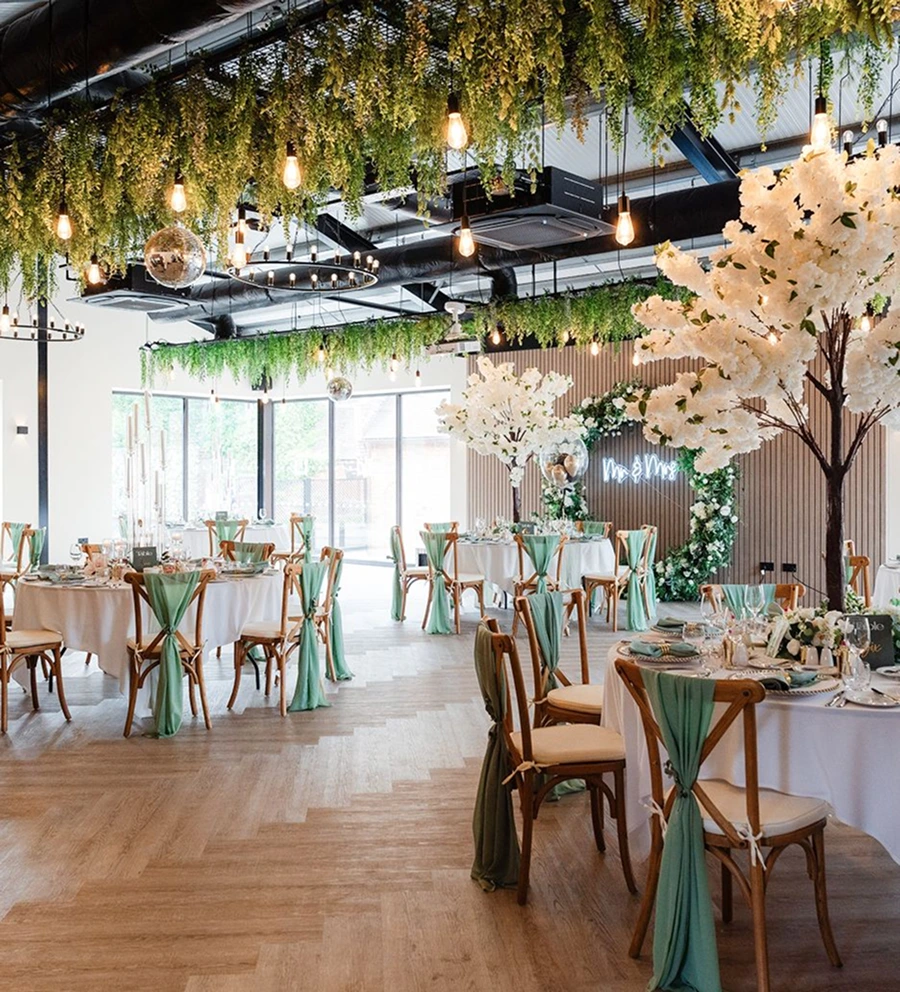 The Cow Shed dressed with hanging foliage and sage green table styling at Blackbrook Barns, Lichfield, Staffordshire