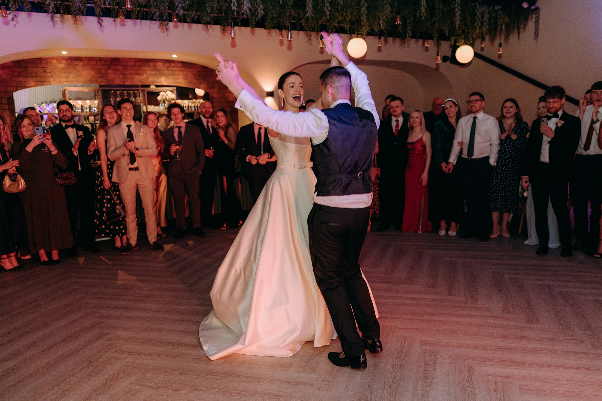 Newlyweds during their first dance with guests watching at Blackbrook Barns, Lichfield, Staffordshire