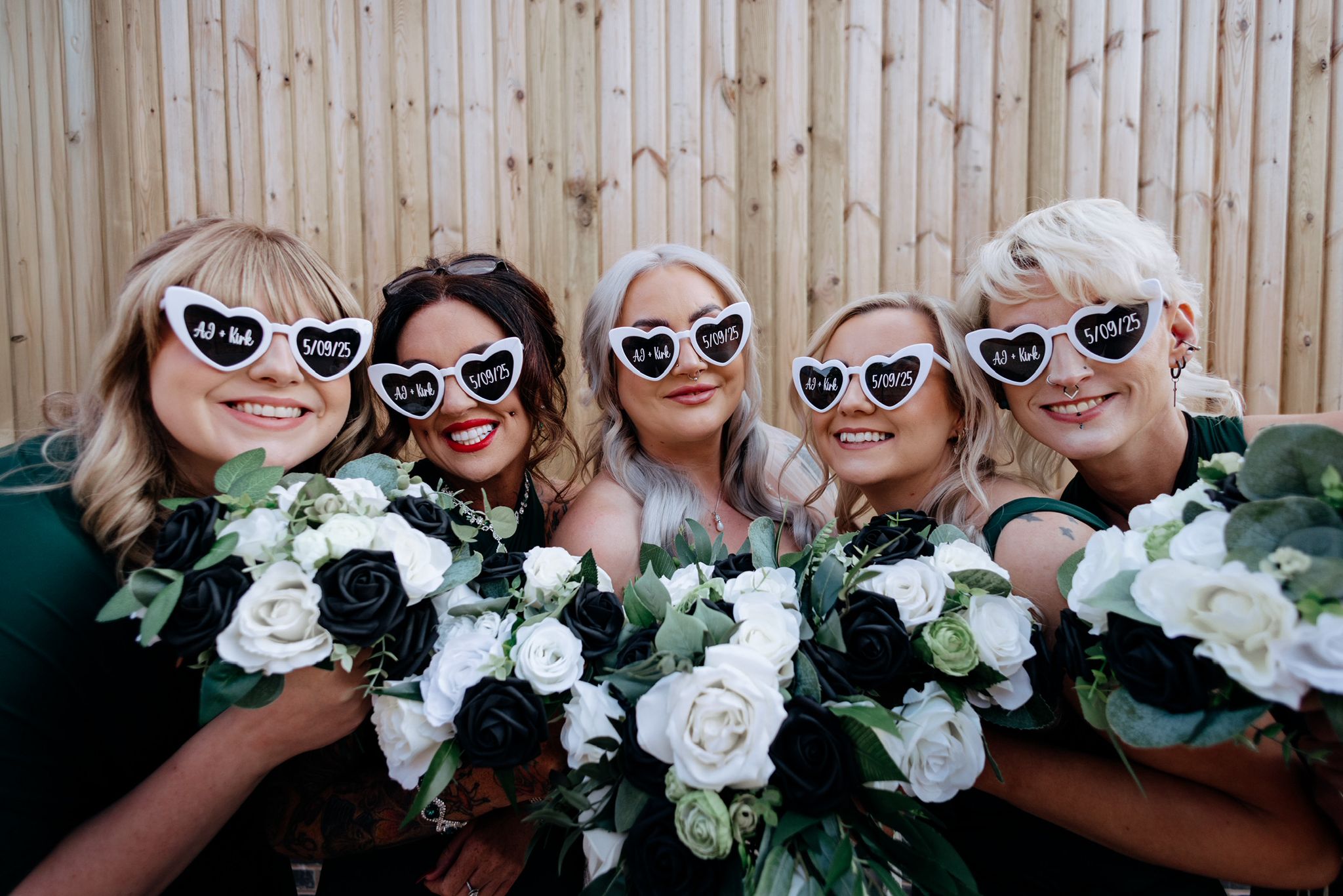 Bridesmaids holding black and white rose bouquets at Blackbrook Barns, Lichfield, Staffordshire