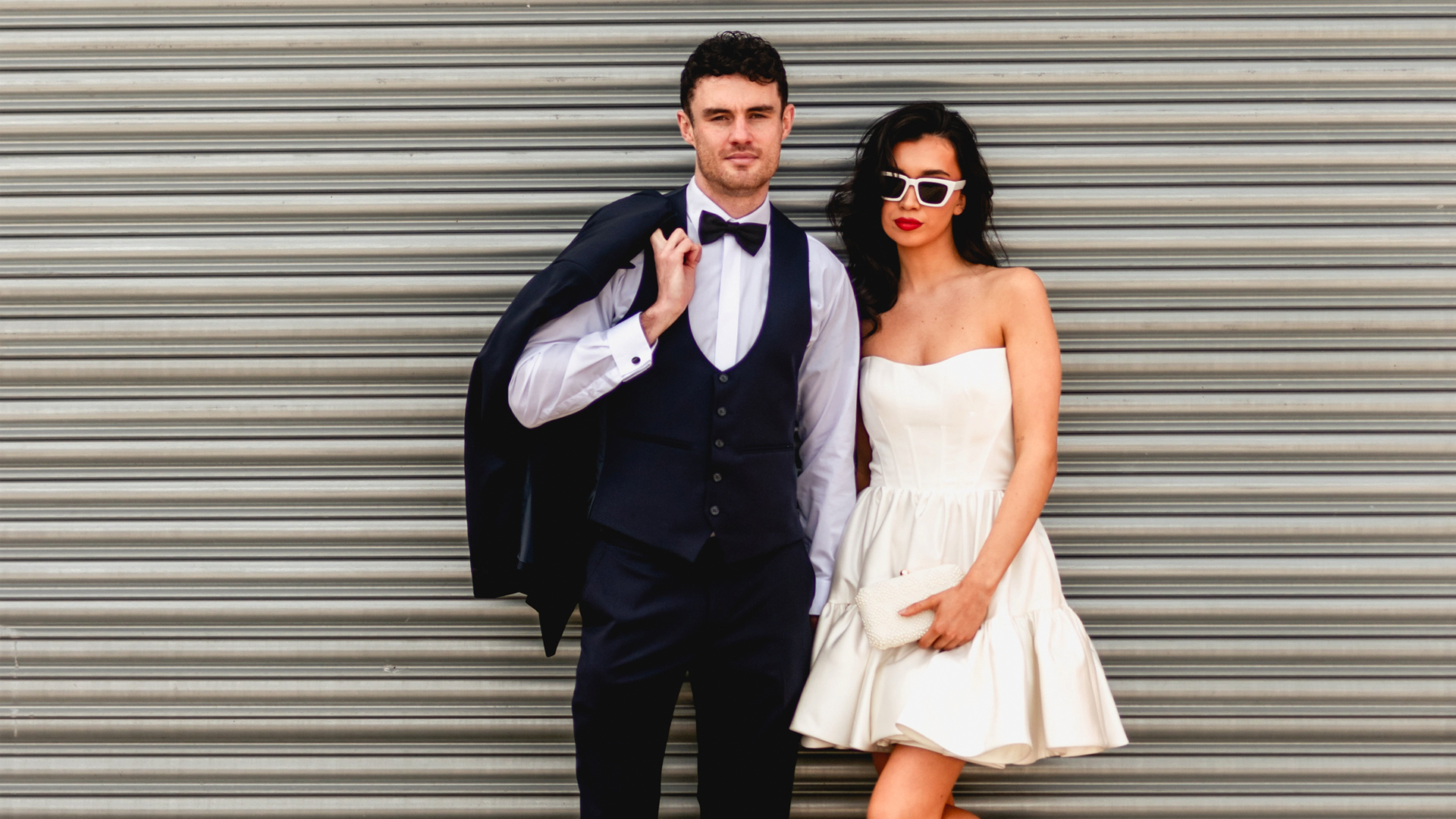 Bride and groom in contemporary wedding style against a corrugated metal backdrop