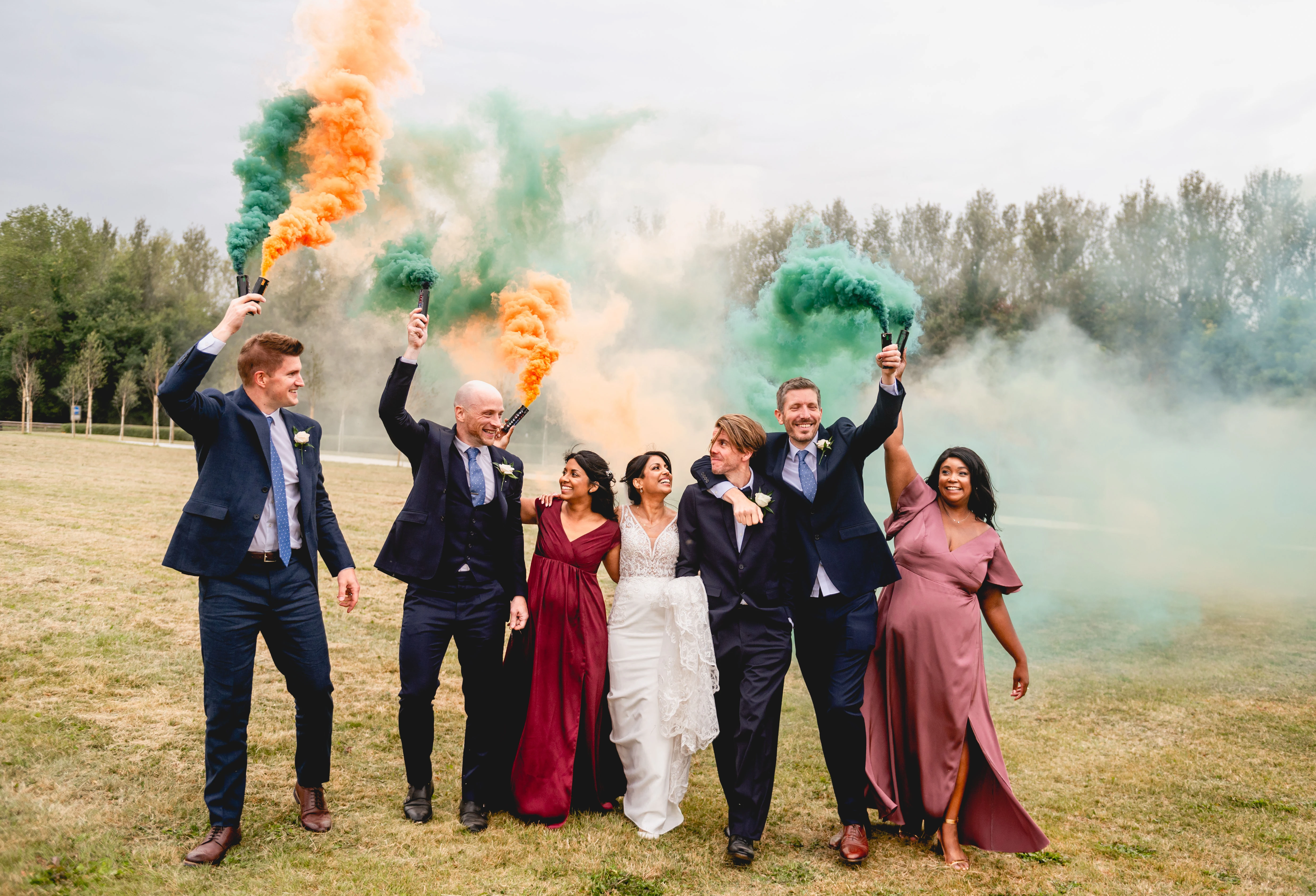Wedding party celebrating with coloured smoke flares