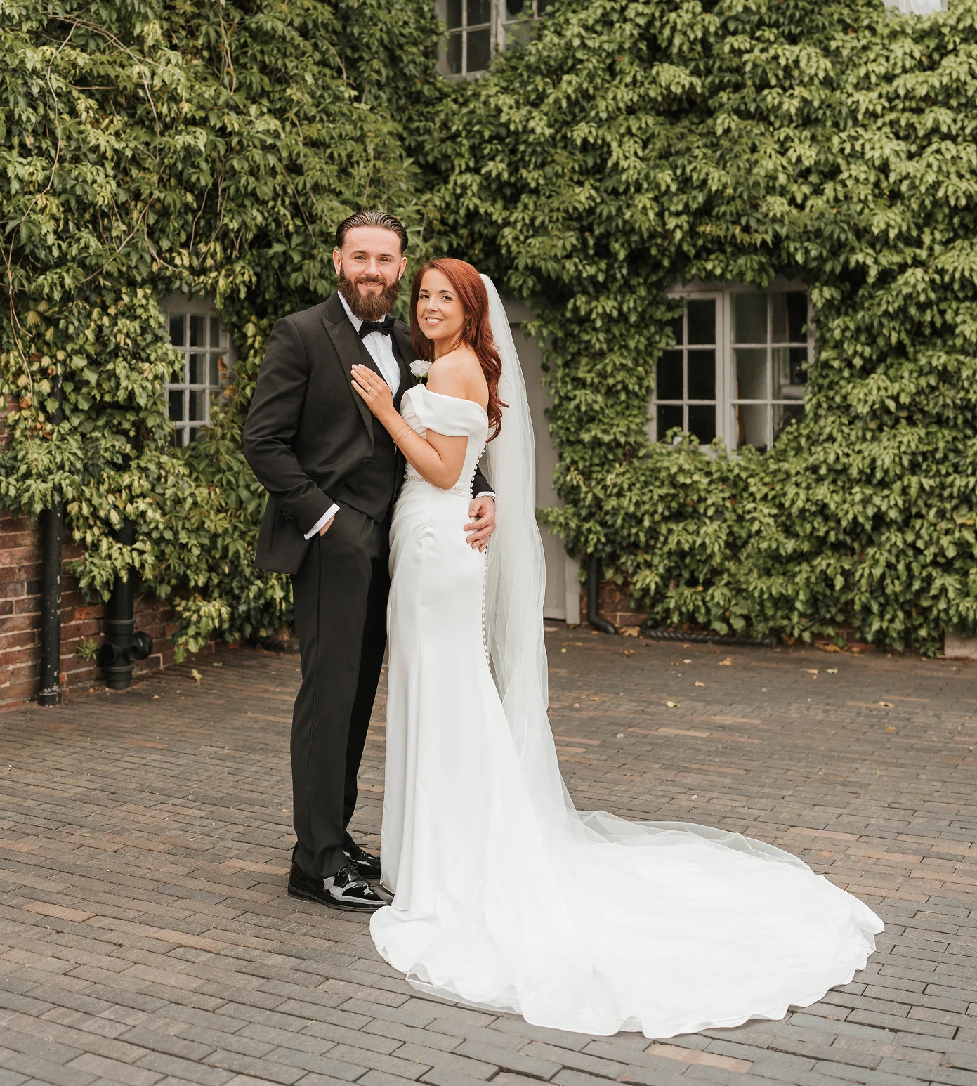 Bride and groom in front of the ivy-covered courtyard building at Blackbrook Barns, Lichfield, Staffordshire