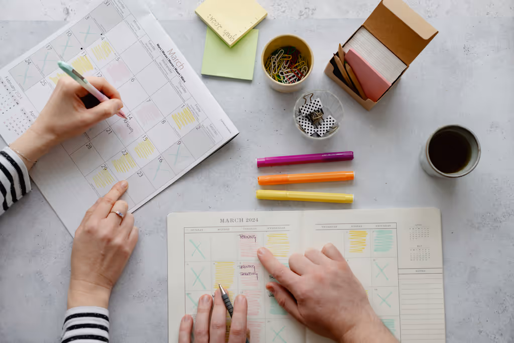 Planification mensuelle avec calendrier, stylos colorés et notes adhésives
