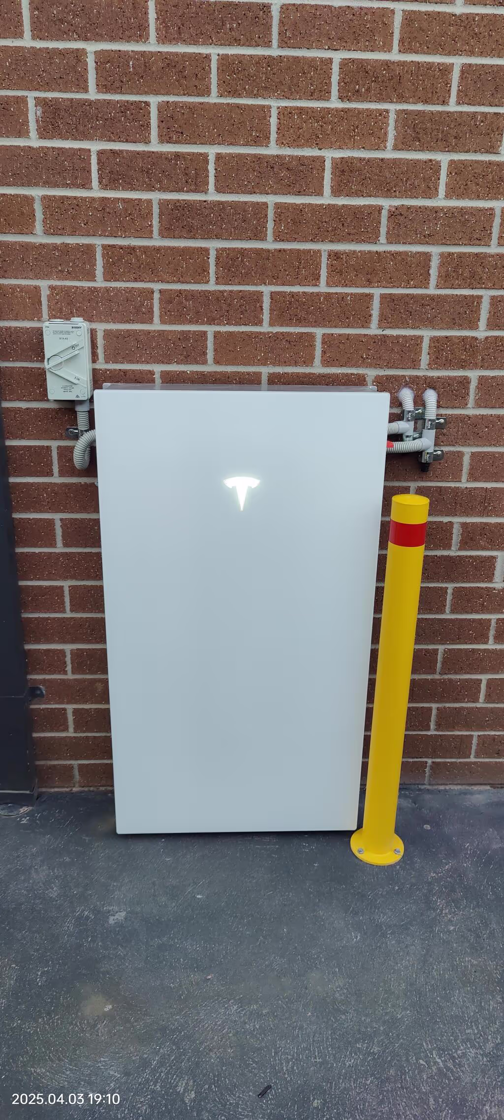 Tesla powerwall 3 installed against a brick wall