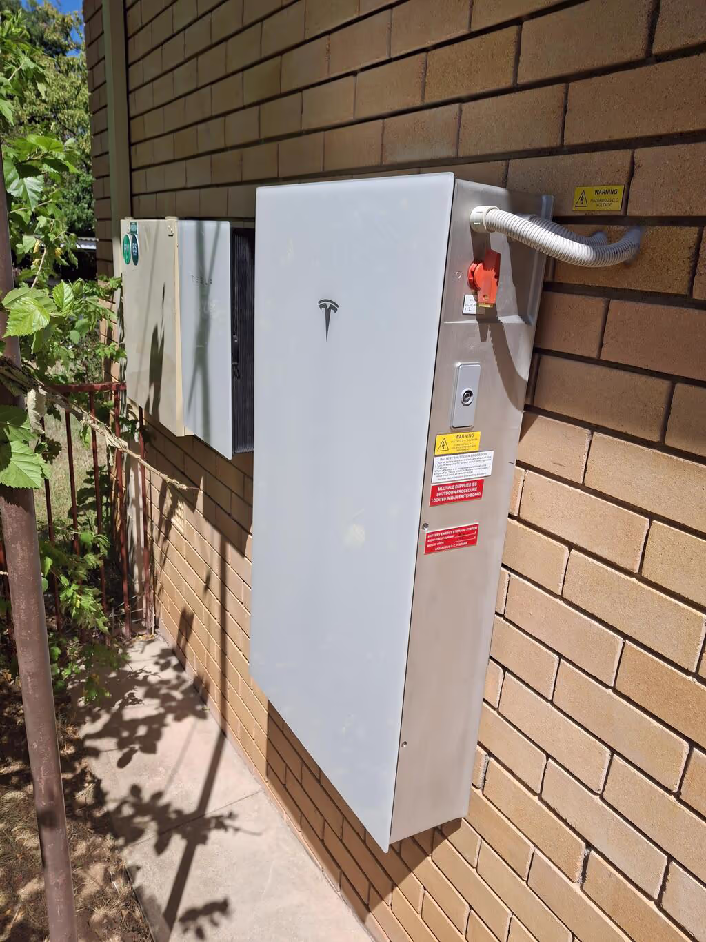 Tesla powerwall 3 installed held on a brick wall