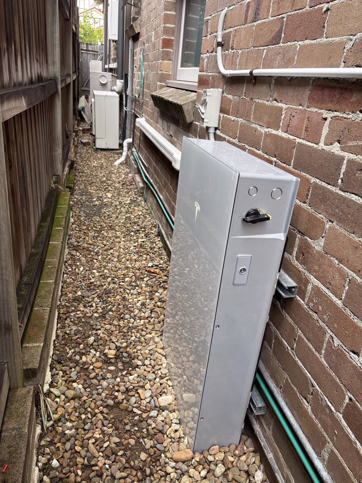 Tesla Powerwall 3 installed down the side of a residential home