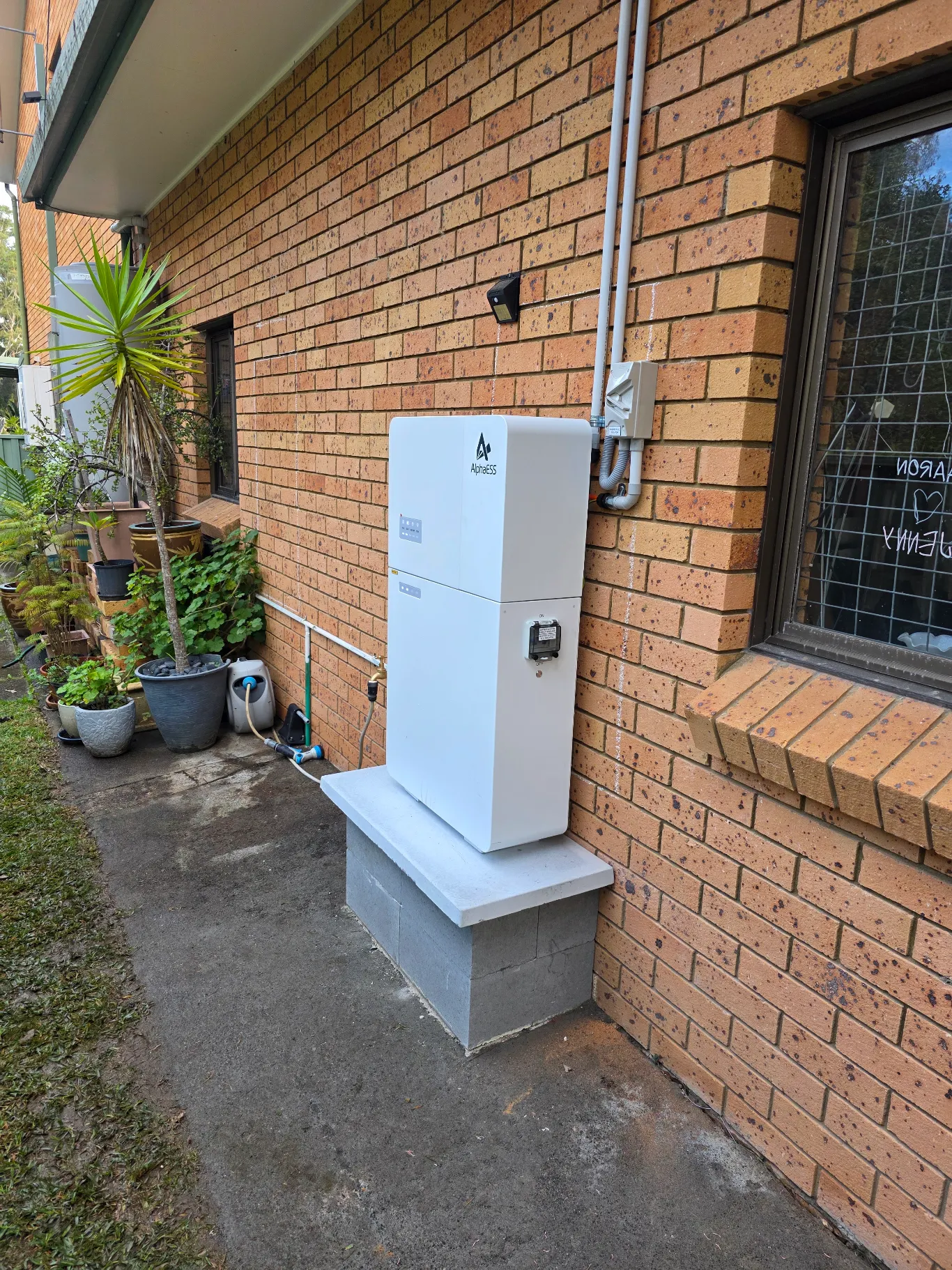 Alpha ESS battery installed against the wall of a residential home