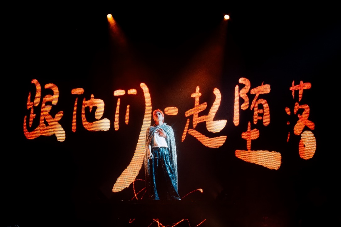 A person on stage with lights

Description automatically generated