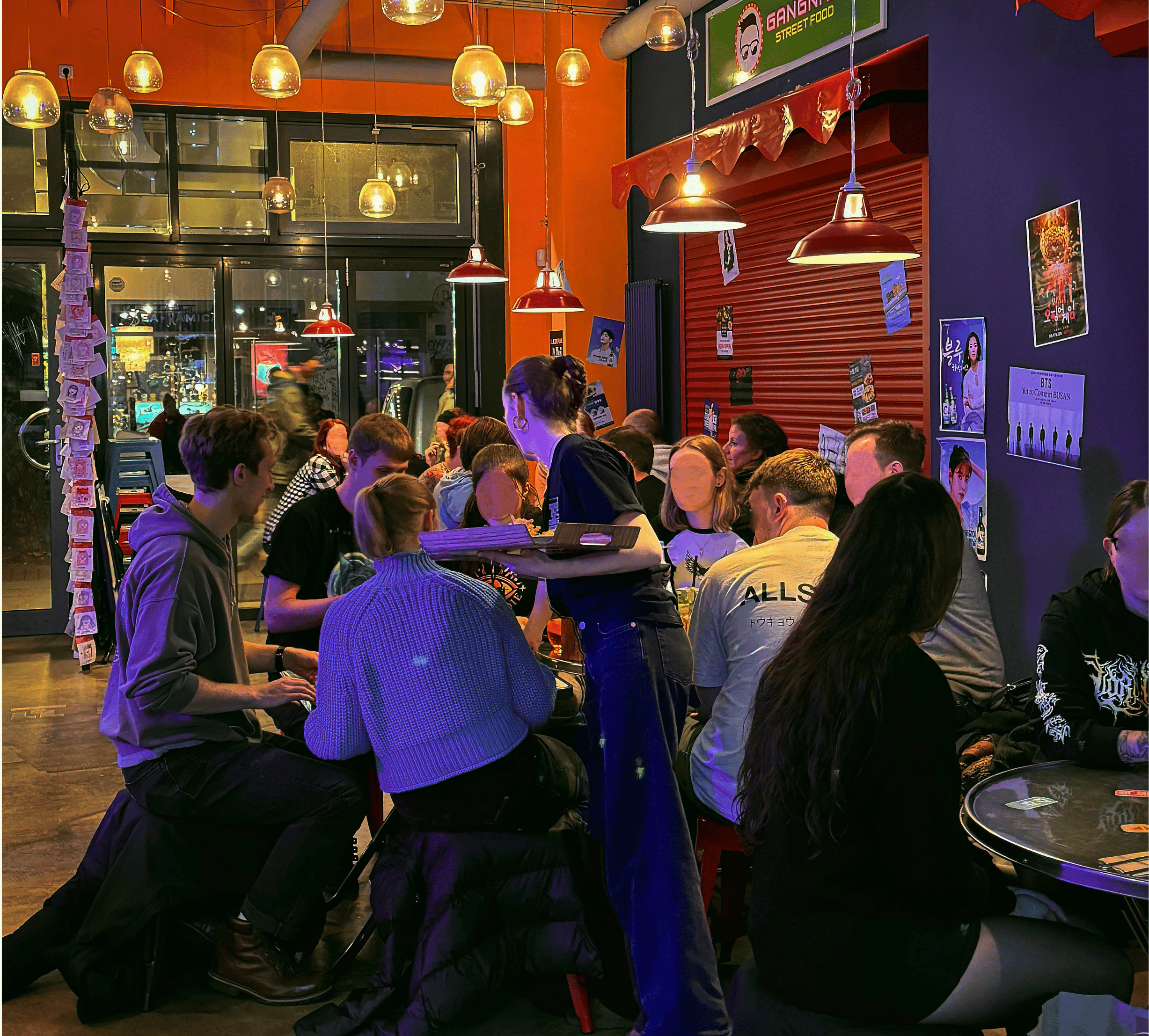 eine Kellnerin dabei wie sie im bunten und fröhlichem Kkokki Loves vegan, koreanisches veganes Essen serviert.