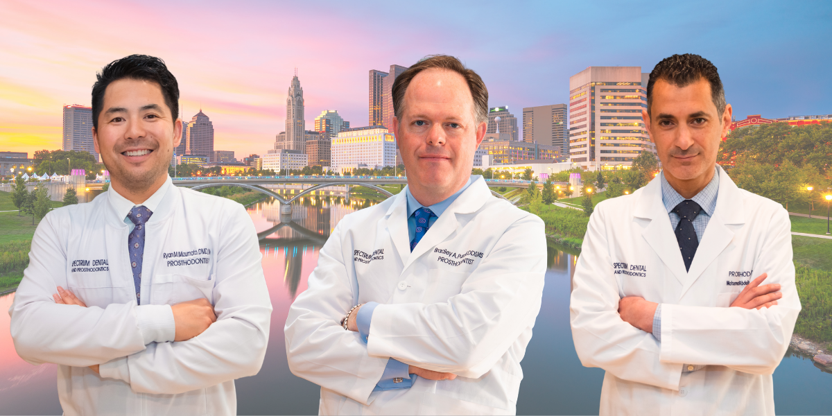 Three medical professionals in lab coats stand confidently with arms crossed, set against a vibrant skyline at sunset.