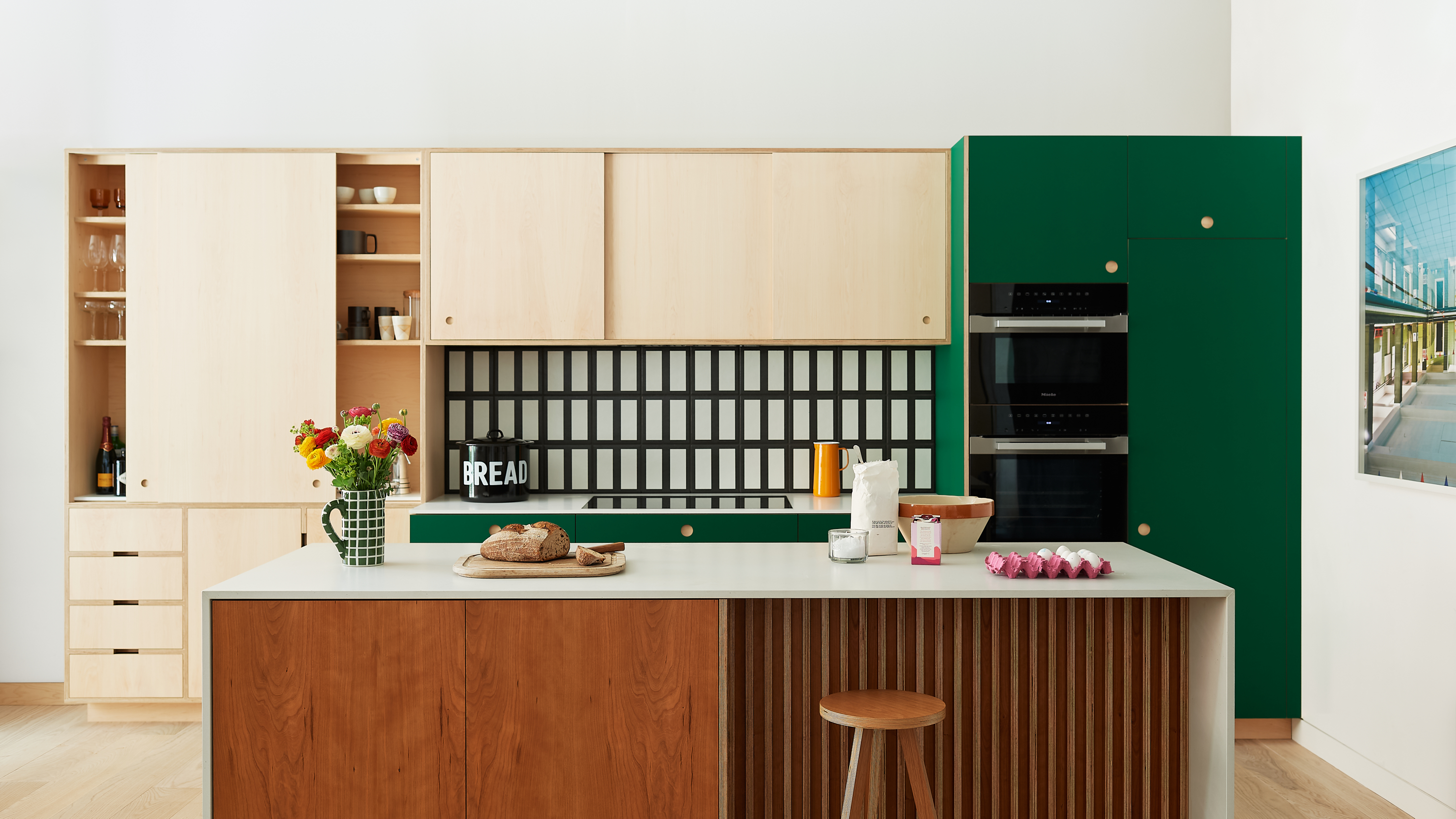 Contemporary bespoke kitchen by Uncommon Projects with plywood cabinetry, green built-in units and timber island