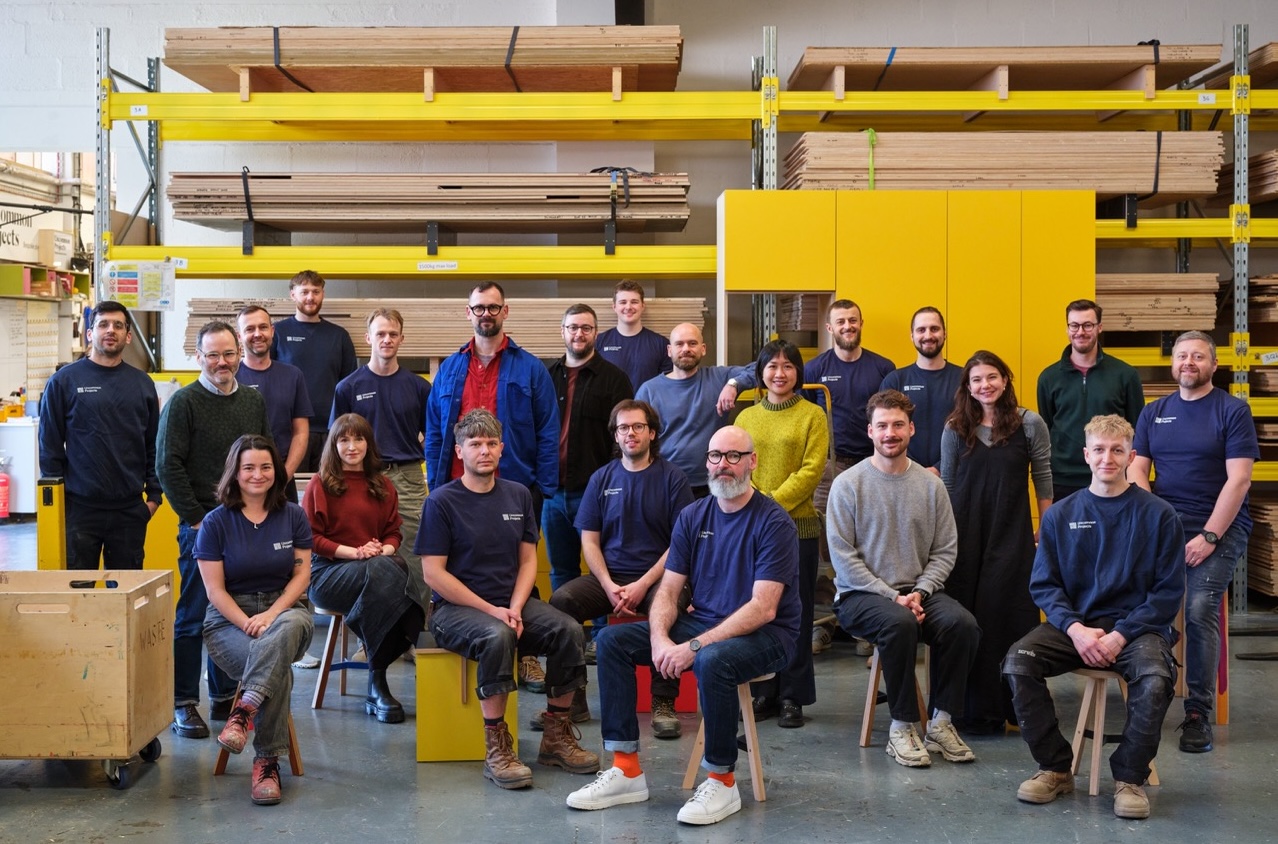 The Uncommon Projects team in their London workshop surrounded by birch plywood sheets and cabinetry components