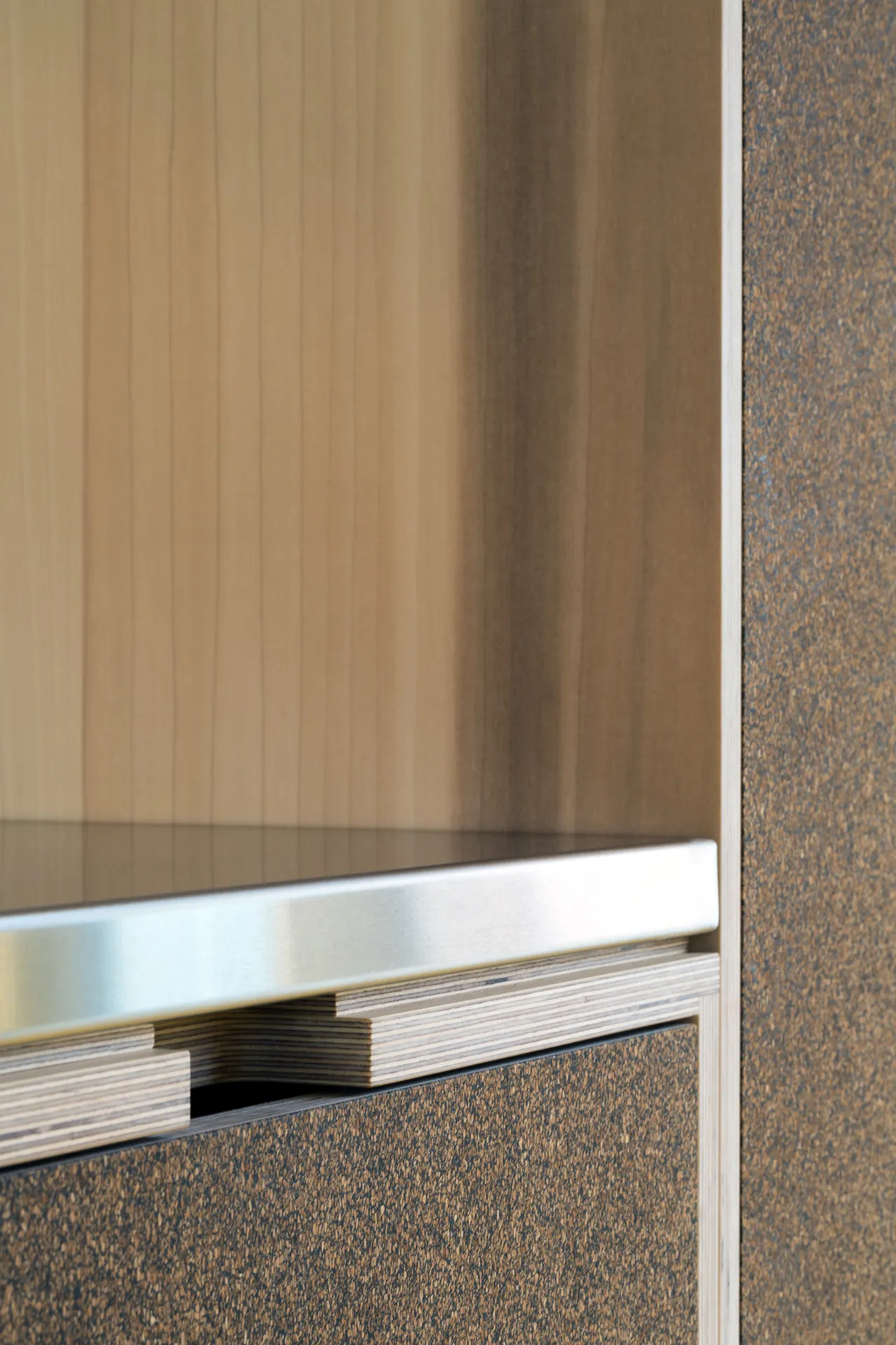 ‘Edge’ handle cut out below a stainless-steel worktop.