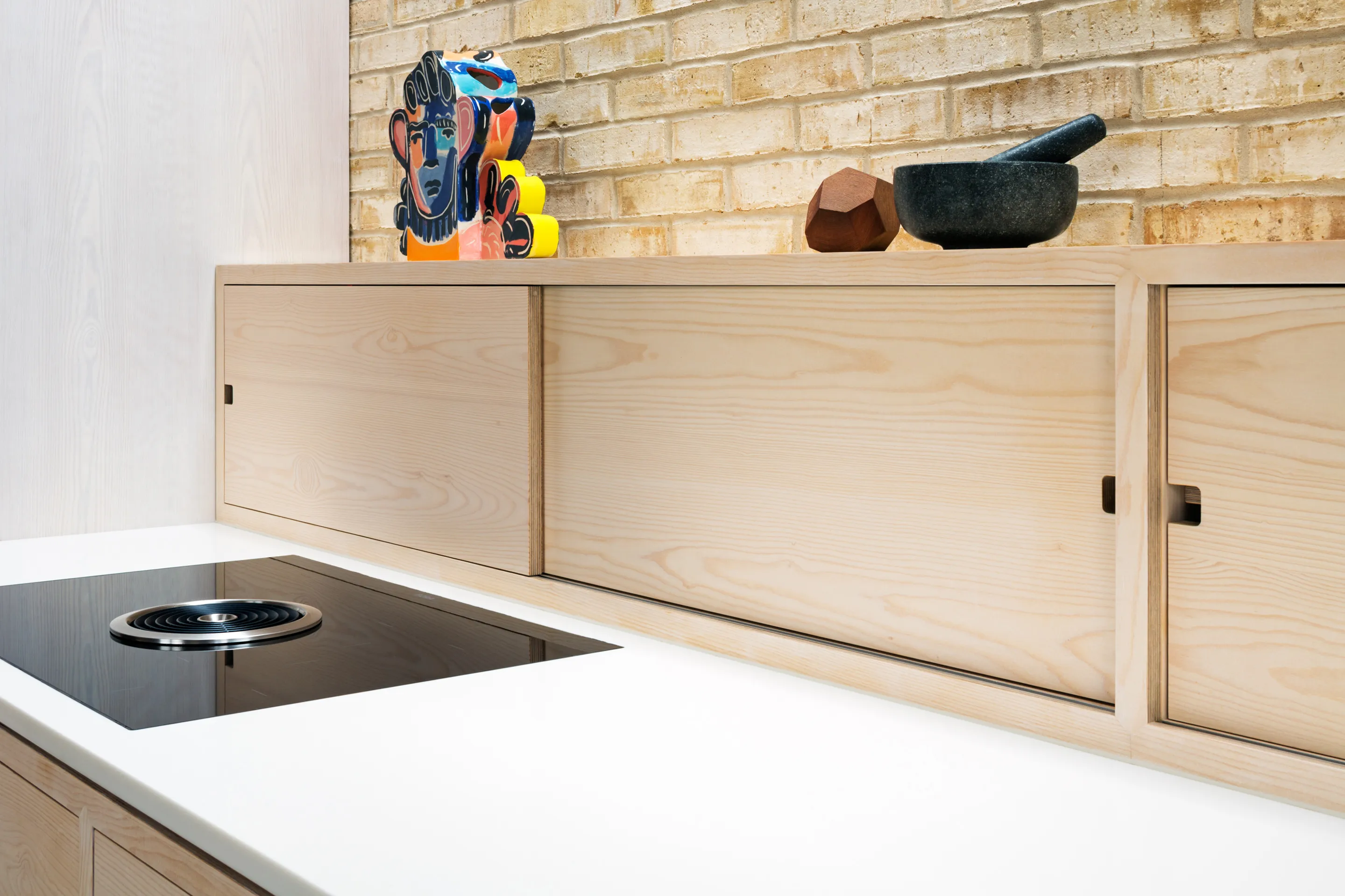 This frame kitchen features splash back storage with doors featuring a cut out finger pull.