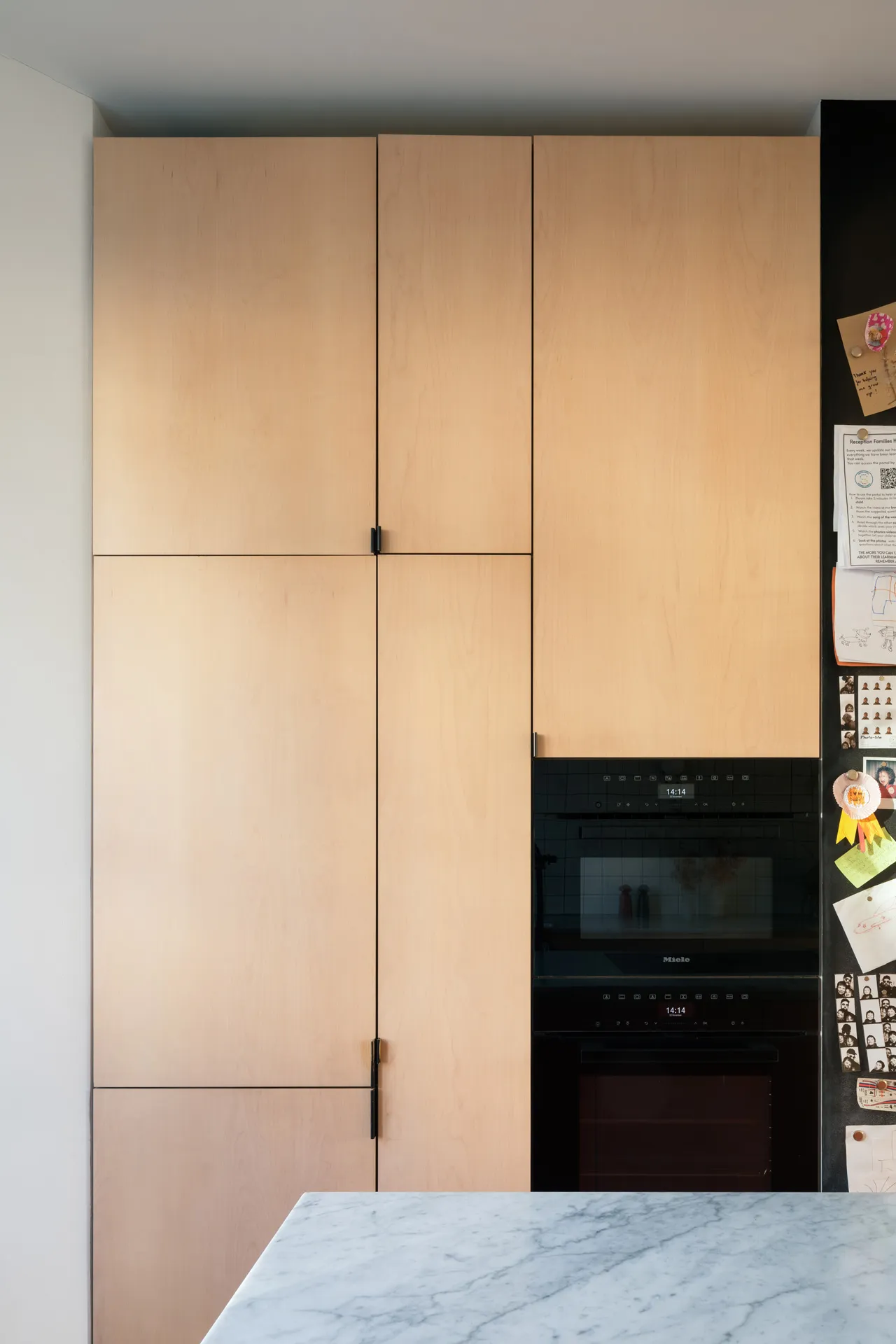 This maple veneered ‘Overlay’ style kitchen features discreet edge pulls with a bronze finish.