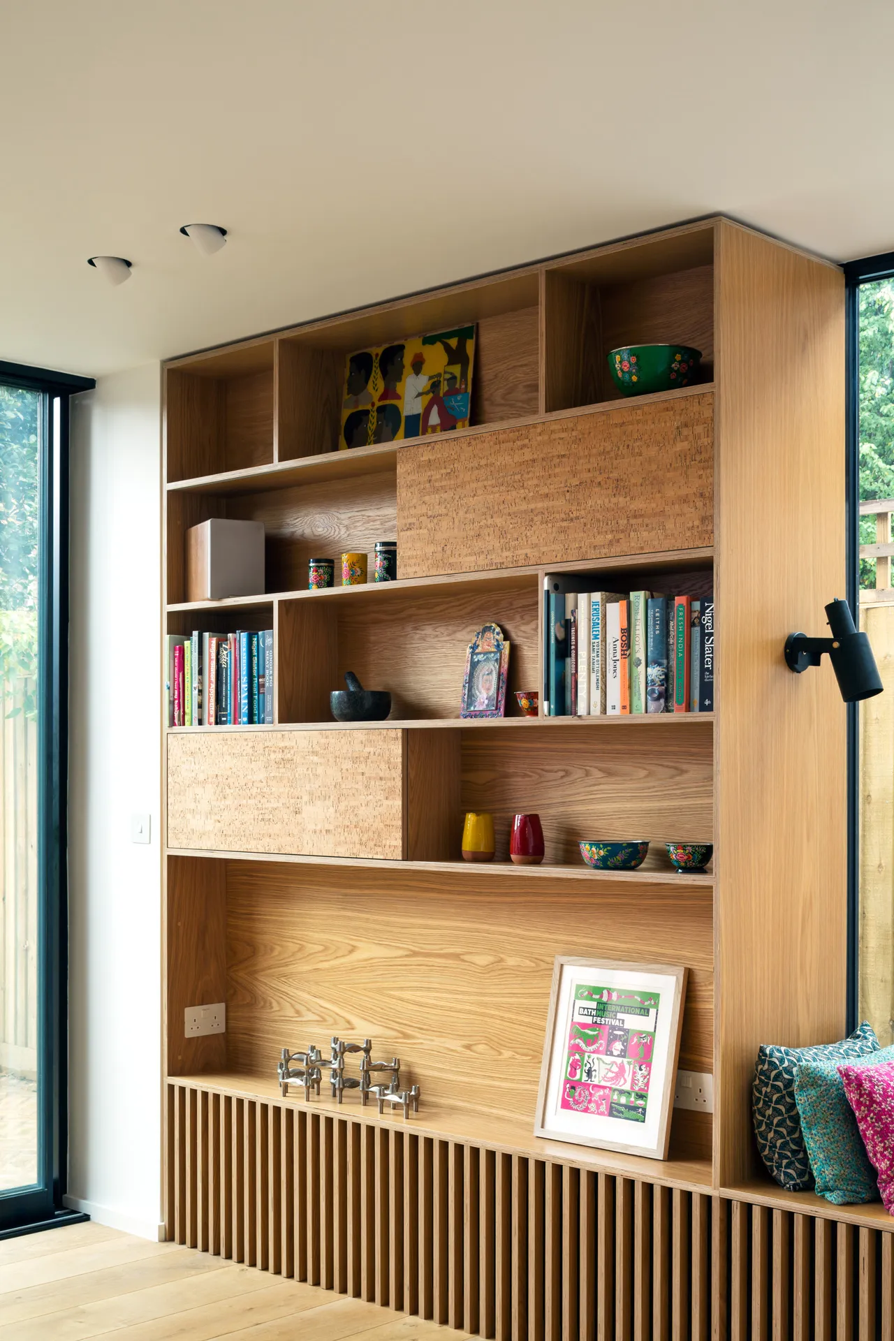 This oak-veneered bookshelf features a slatted radiator cover at low level.