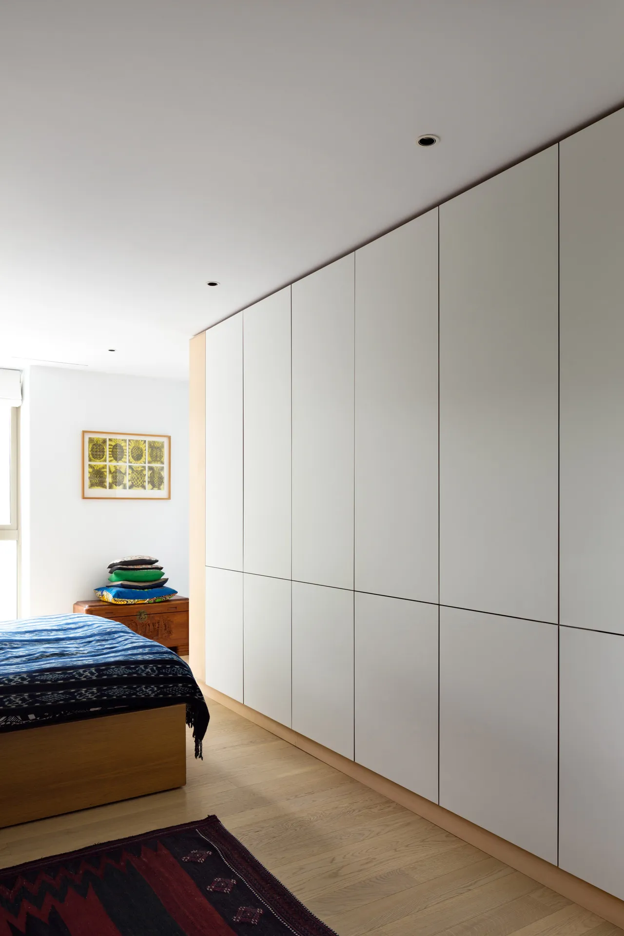 These minimal white wardrobe doors in ‘Overlay’ style feature push to open latches.