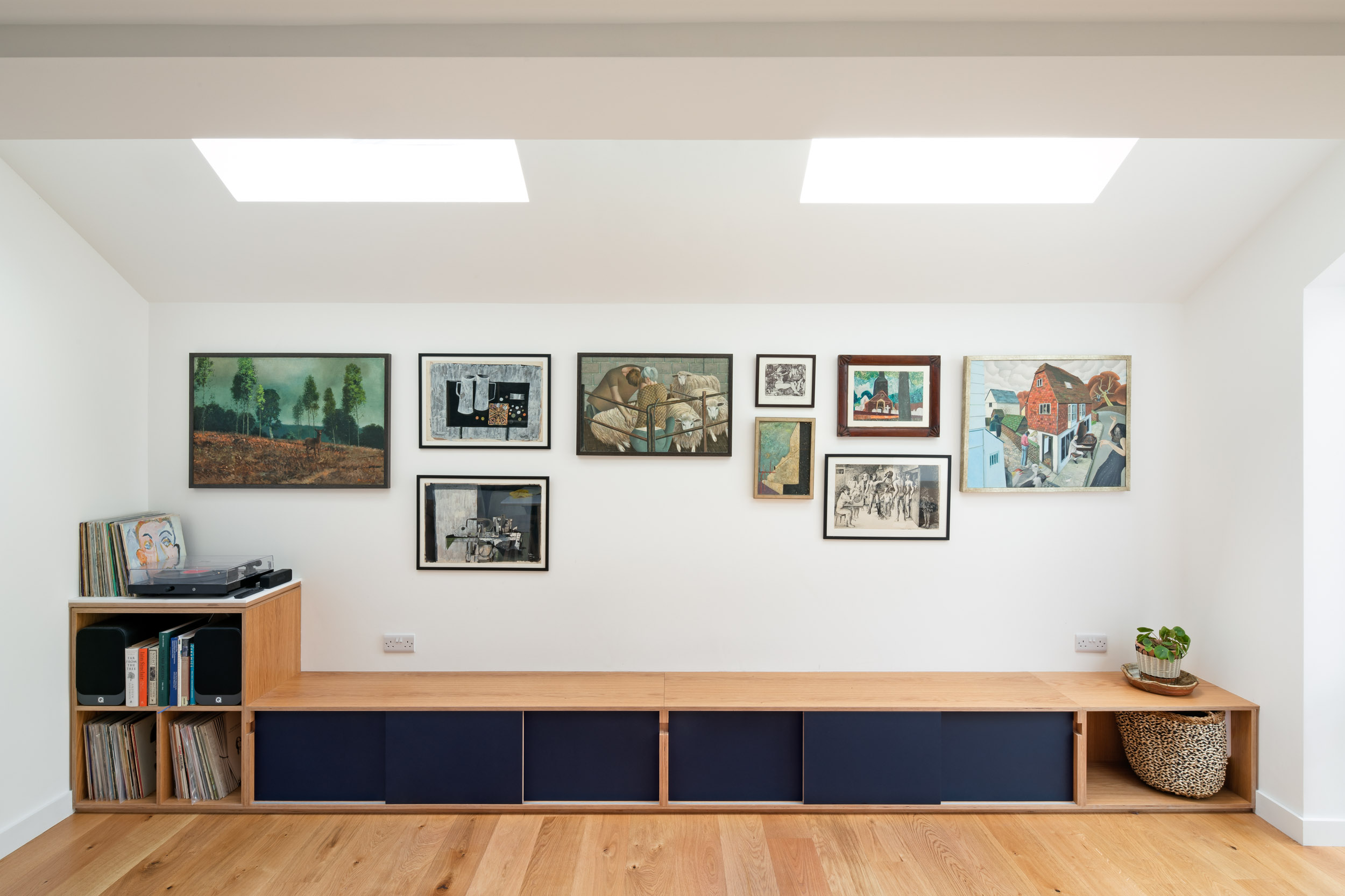 Oak vinyl storage and integrated bench and artwork on the walls