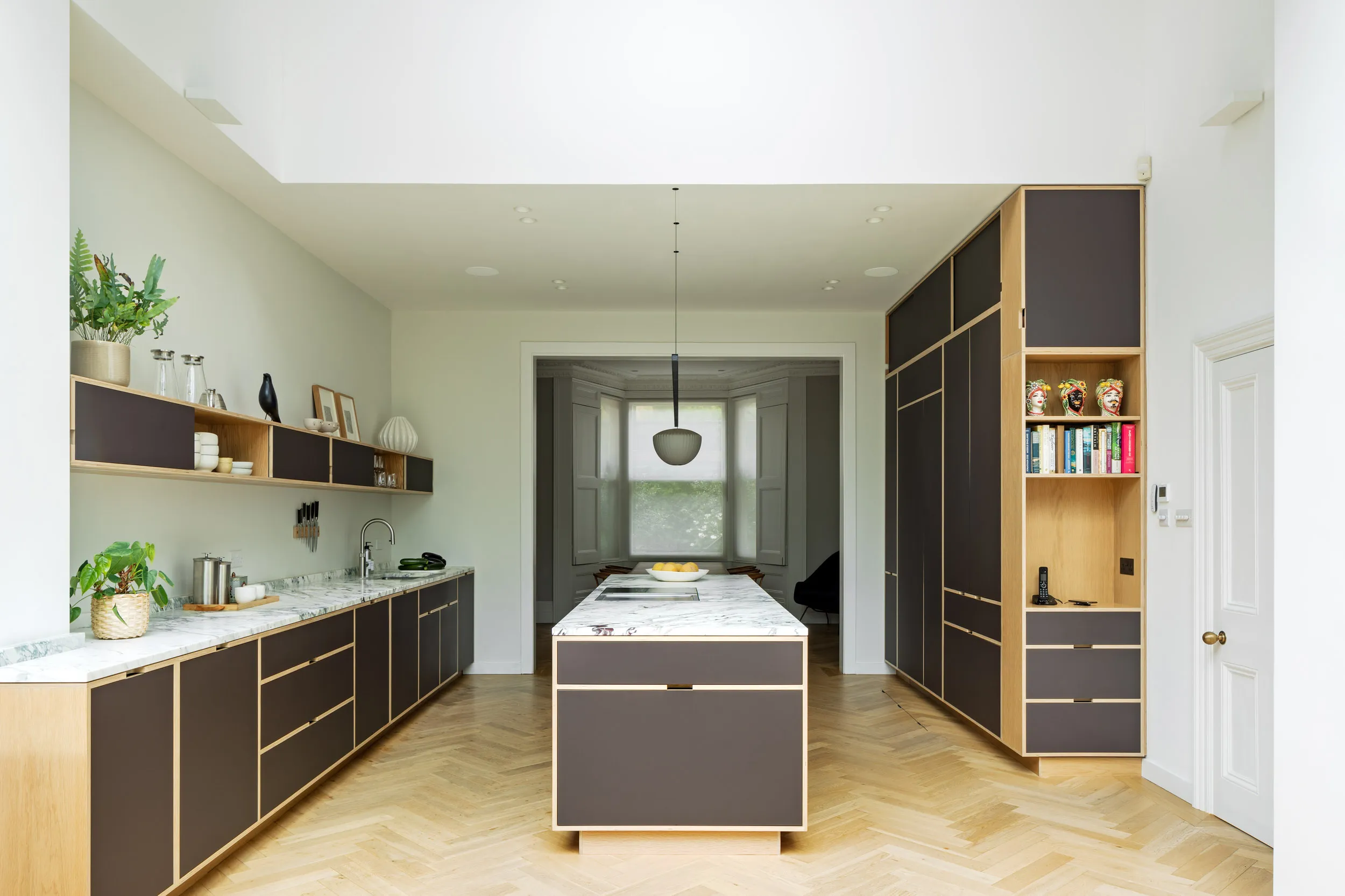 Victorian Villa internal view on bespoke birch plywood kitchen with oak veneer, island and narrow shelving. 