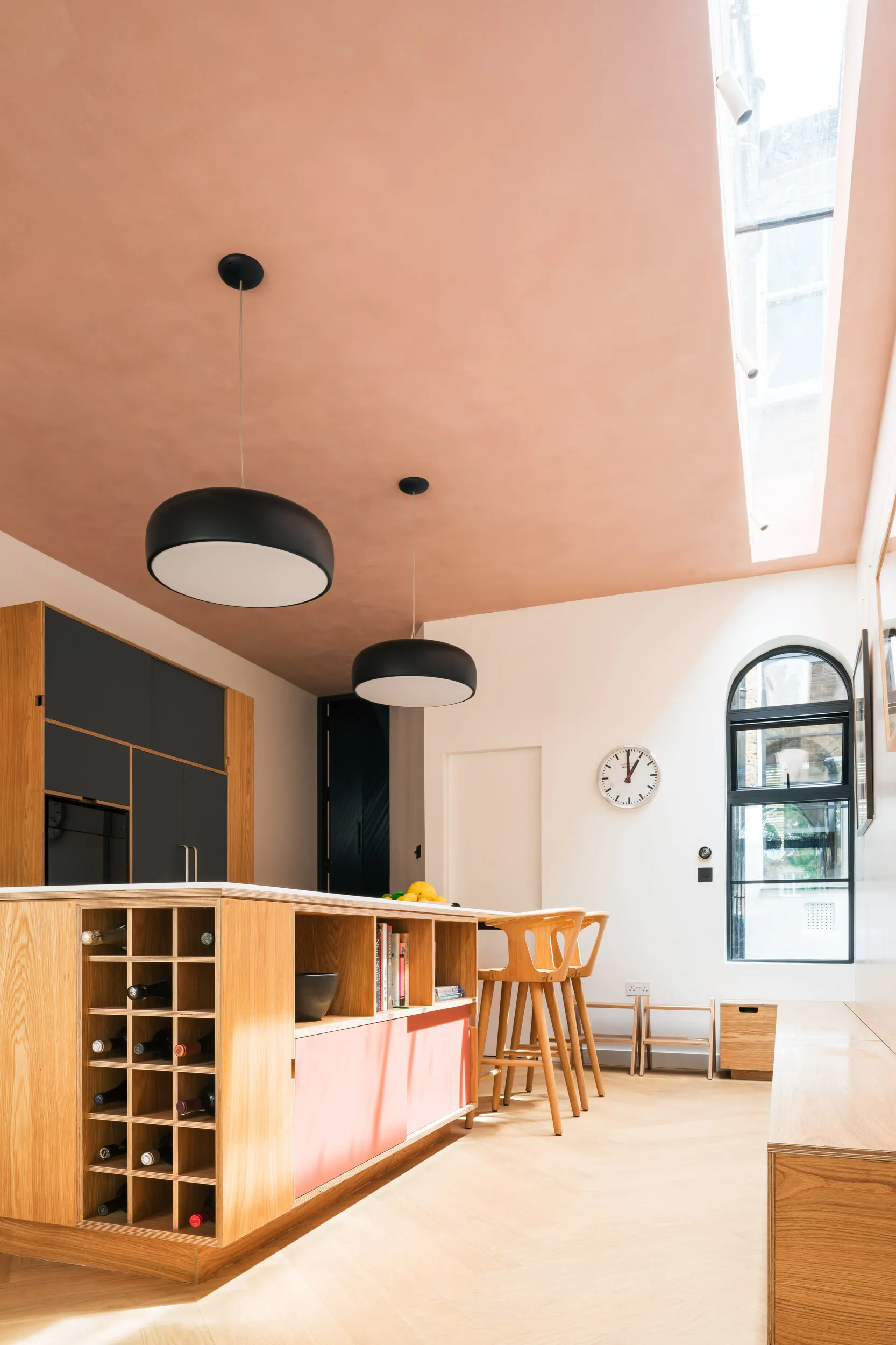 Skylight over bench storage. Plywood island with pink laminate
