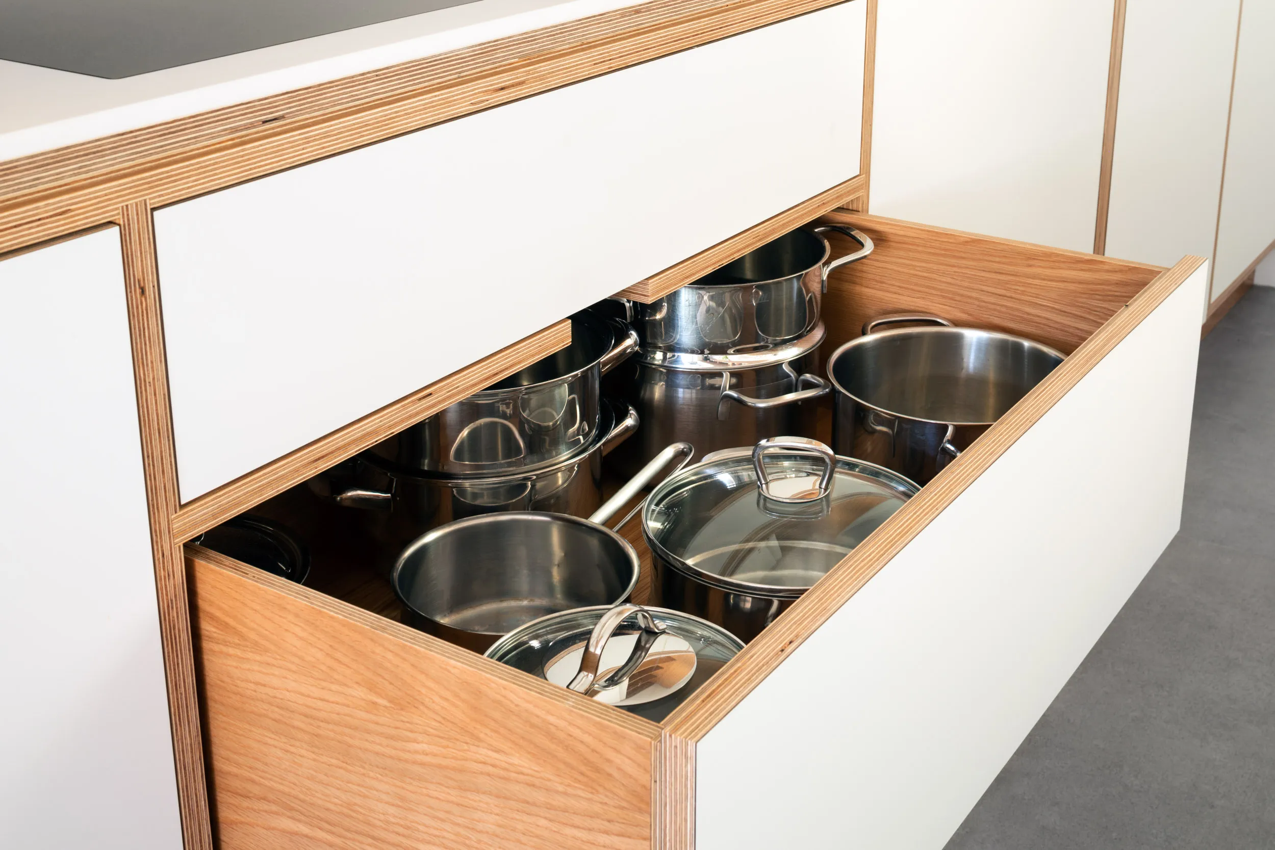 Plywood pan drawer full of pans. 