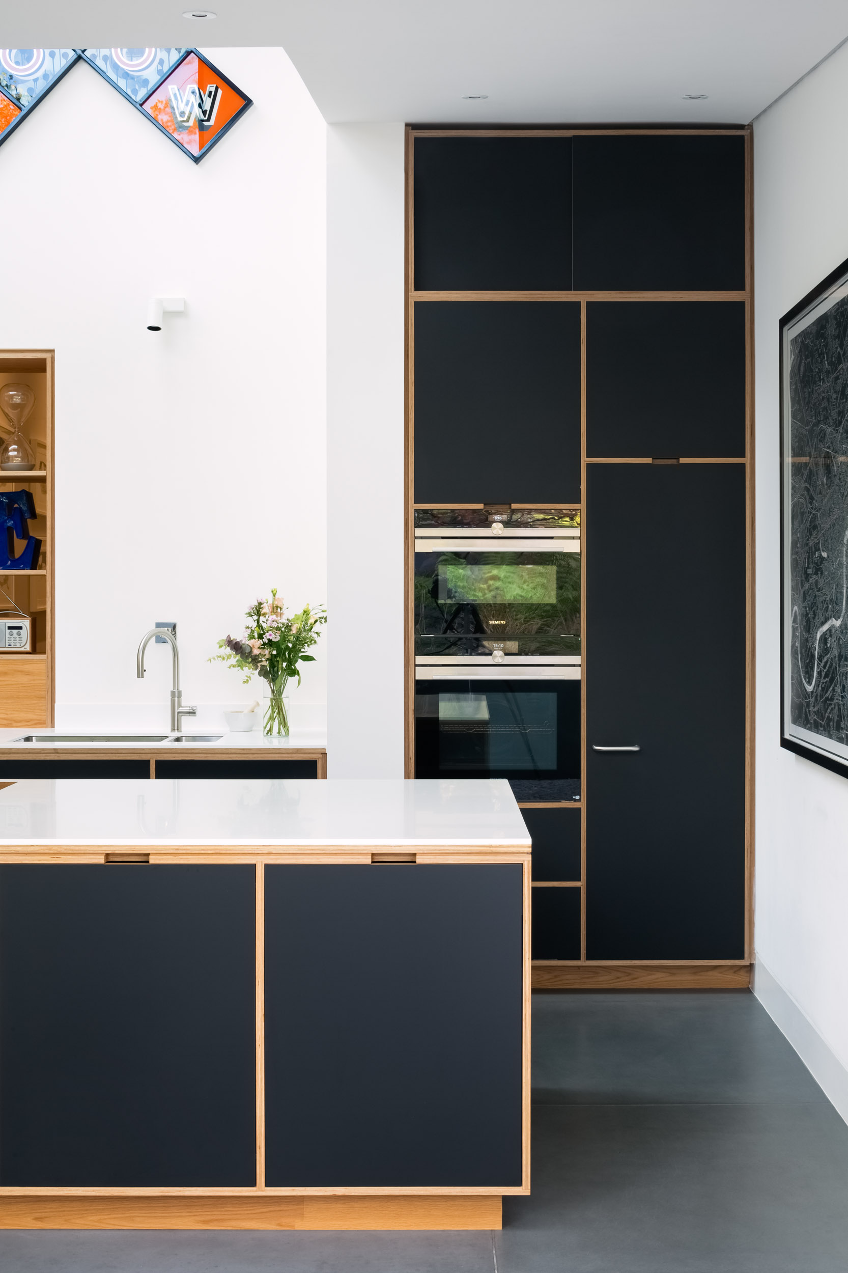 black and ply kitchen with double height cabinetry